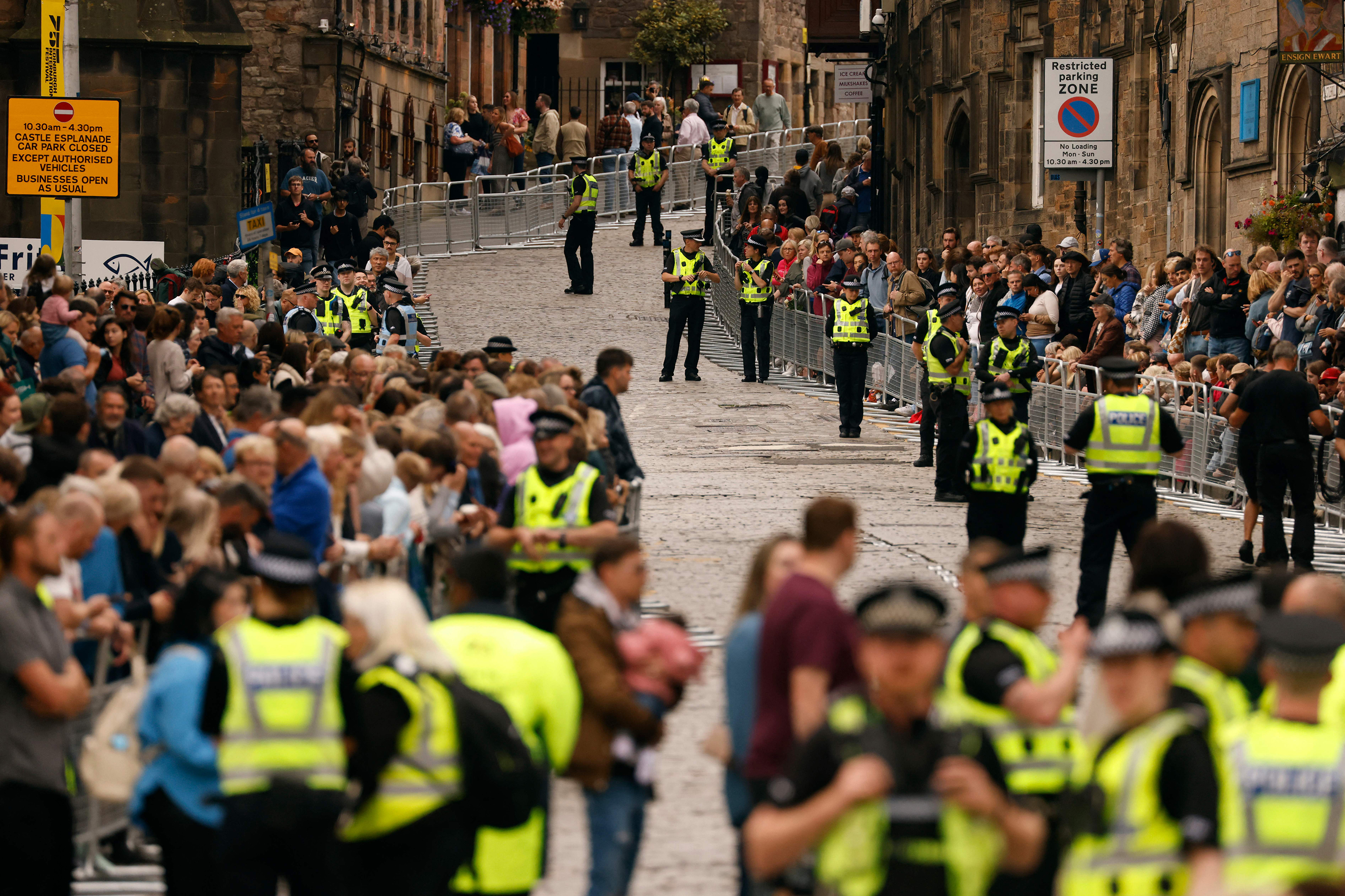 Police officers control the building crowds on Castlehill in Edinburgh on September 11, as preparations are made for the arrival of the coffin of Queen Elizabeth II. 