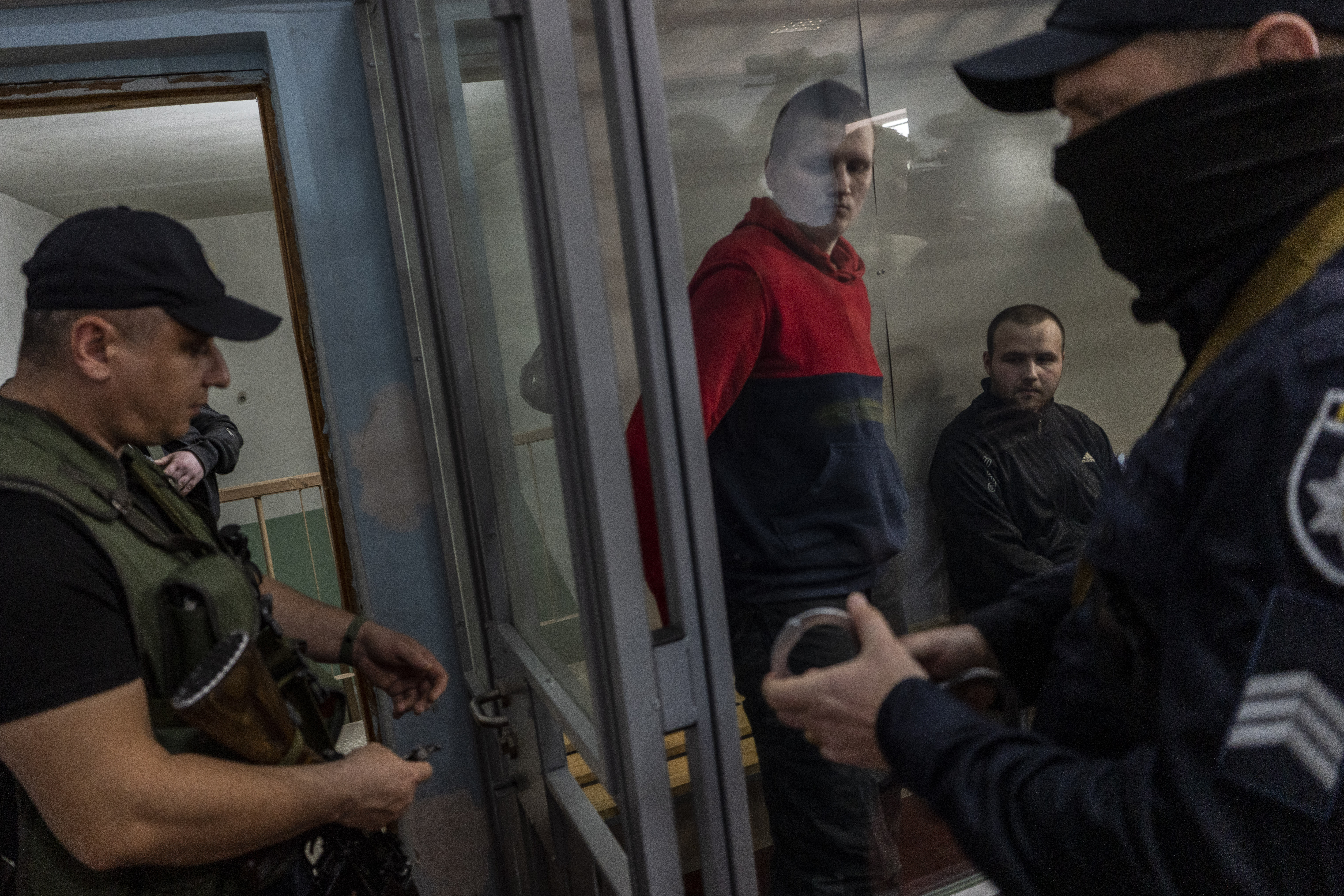 Russian soldiers Alexander Ivanov and Alexander Bobykin, center, in the courtroom after their trial hearing in Kotelva, Ukraine, on May 26. 