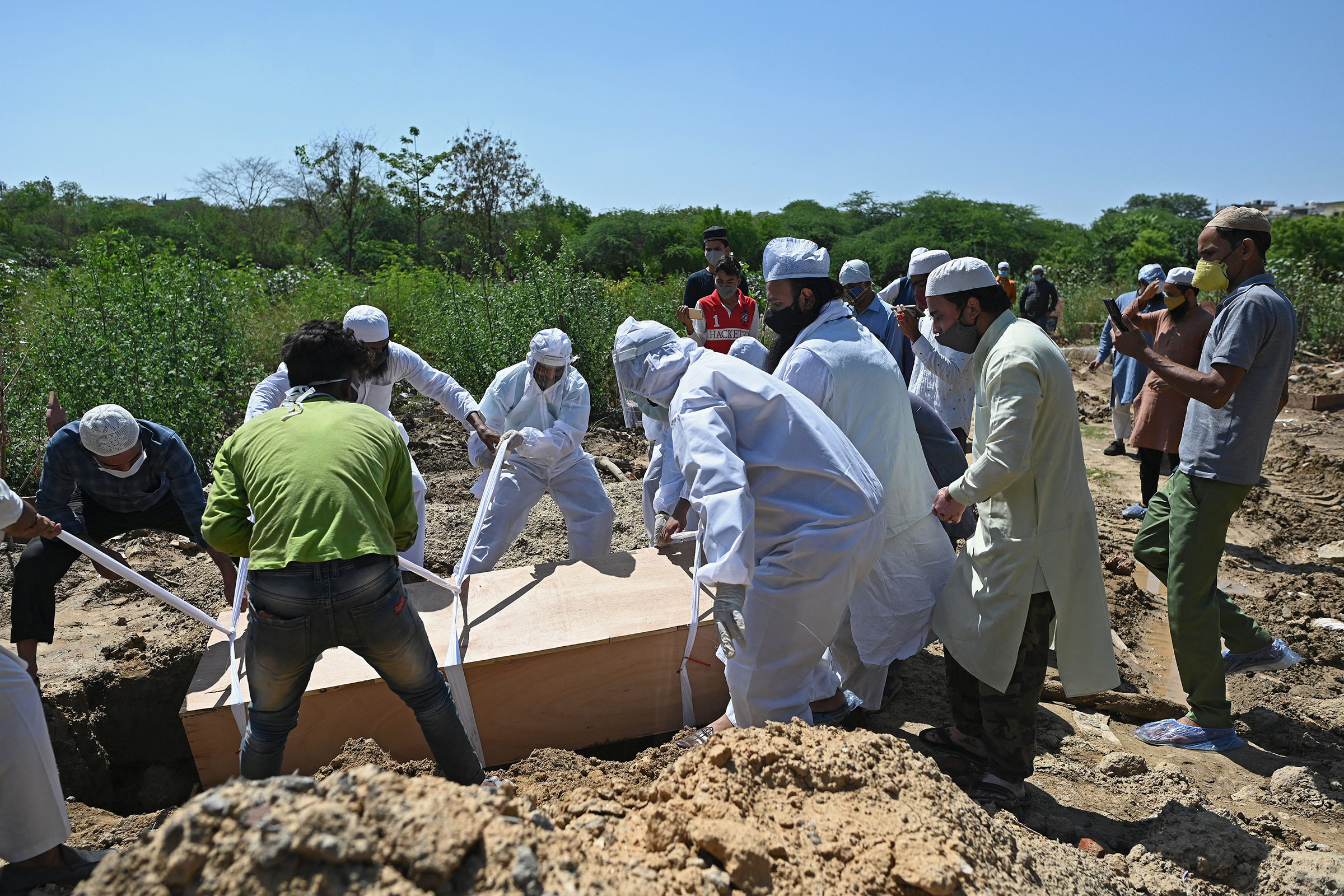 Relatives bury the body of a Covid-19 victim at a graveyard in New Delhi, on May 22. 
