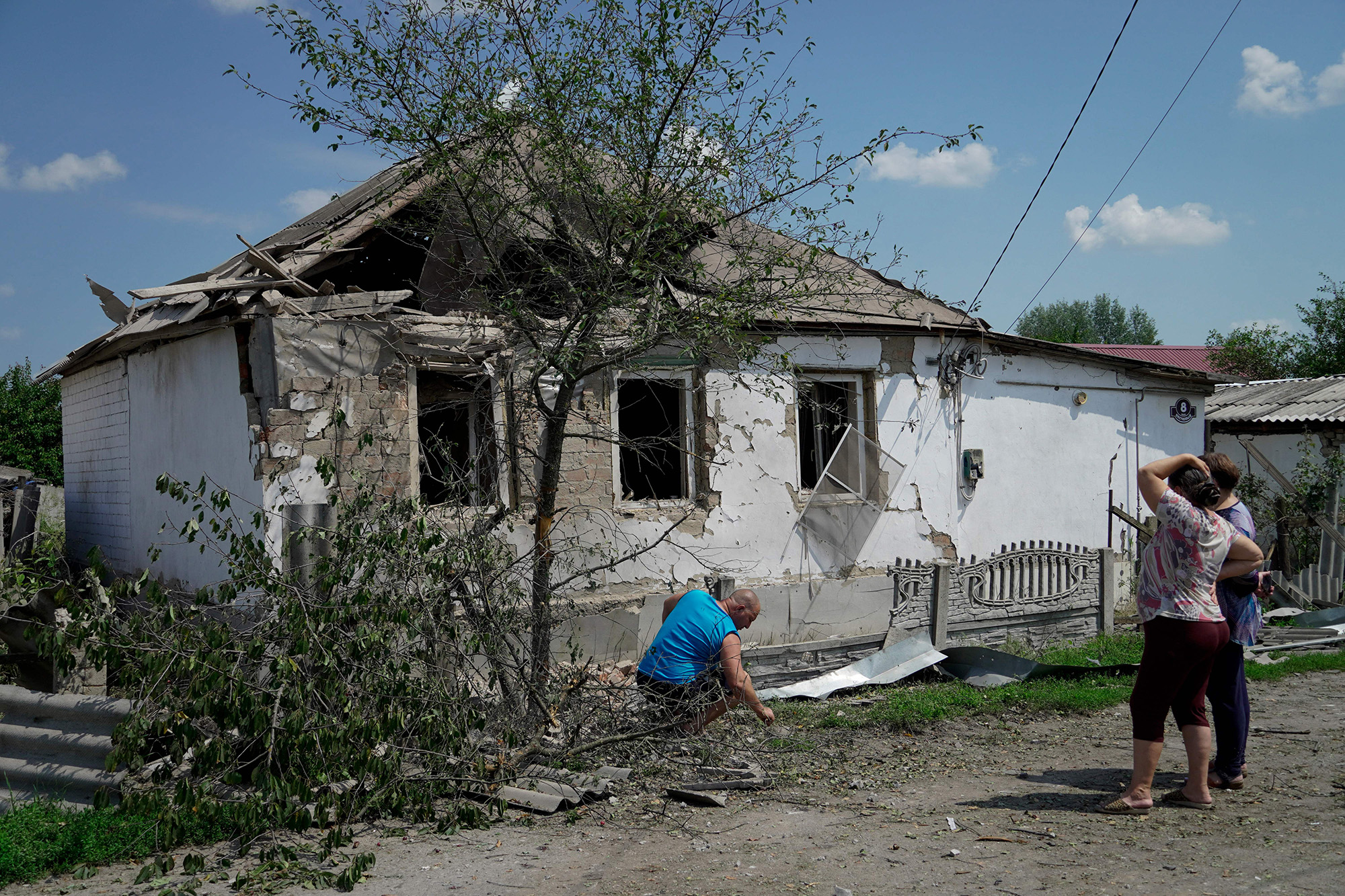 Women look at a house destroyed by recent Ukrainian strikes in the town of Valuyki in the Belgorod region, Russia, on July 5.