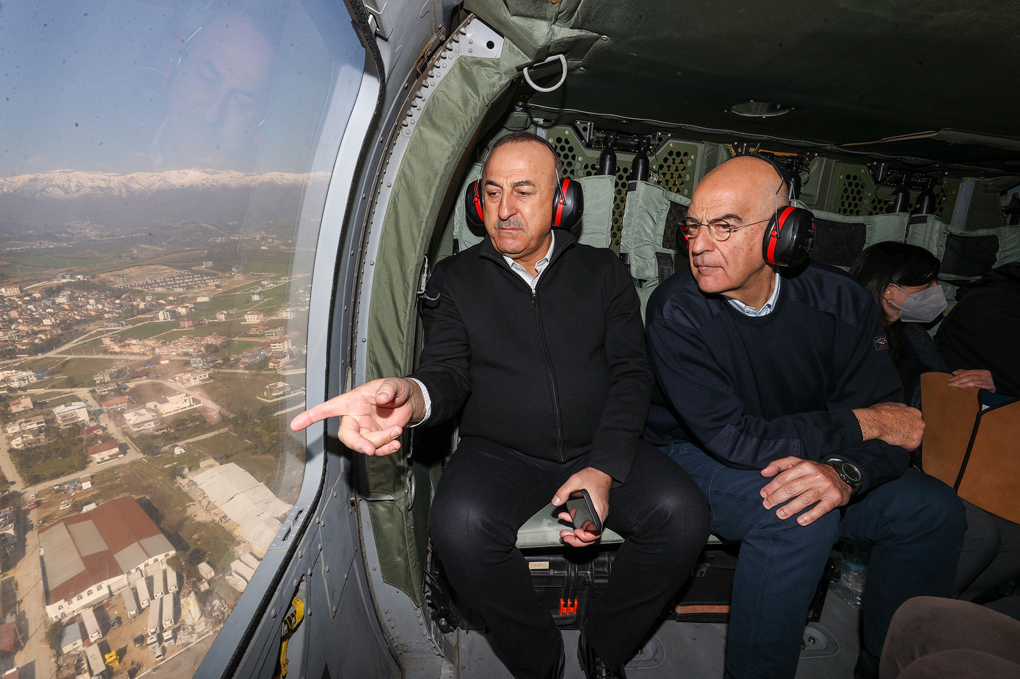 Turkish Foreign Minister Mevlut Cavusoglu, left, and his Greek counterpart Nikos Dendias inspect a quake-hit region in Hatay, Turkey, on February 12.