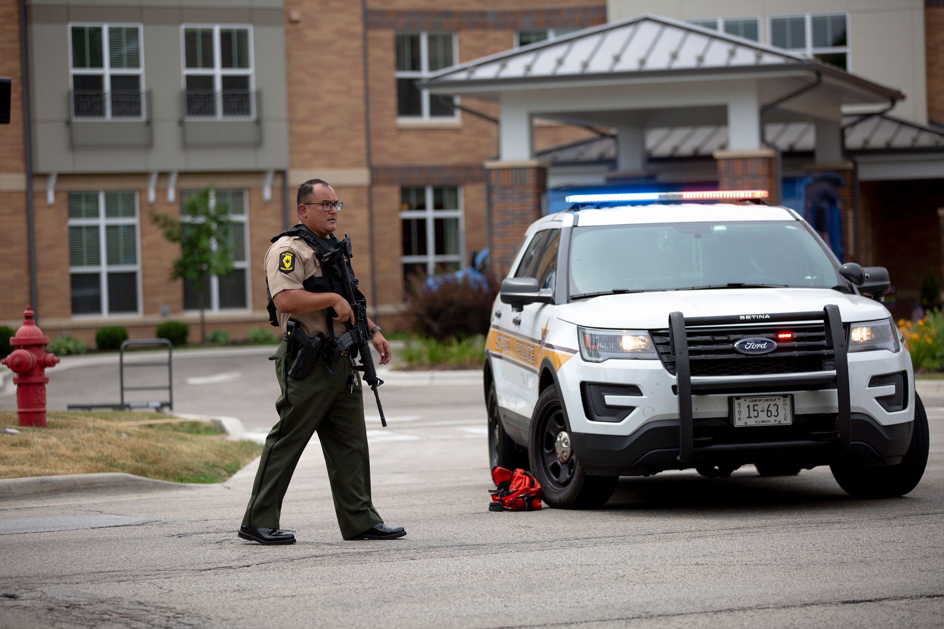 A police officer stands guard at the scene of the shooting in Highland Park, Illinois, on Monday.