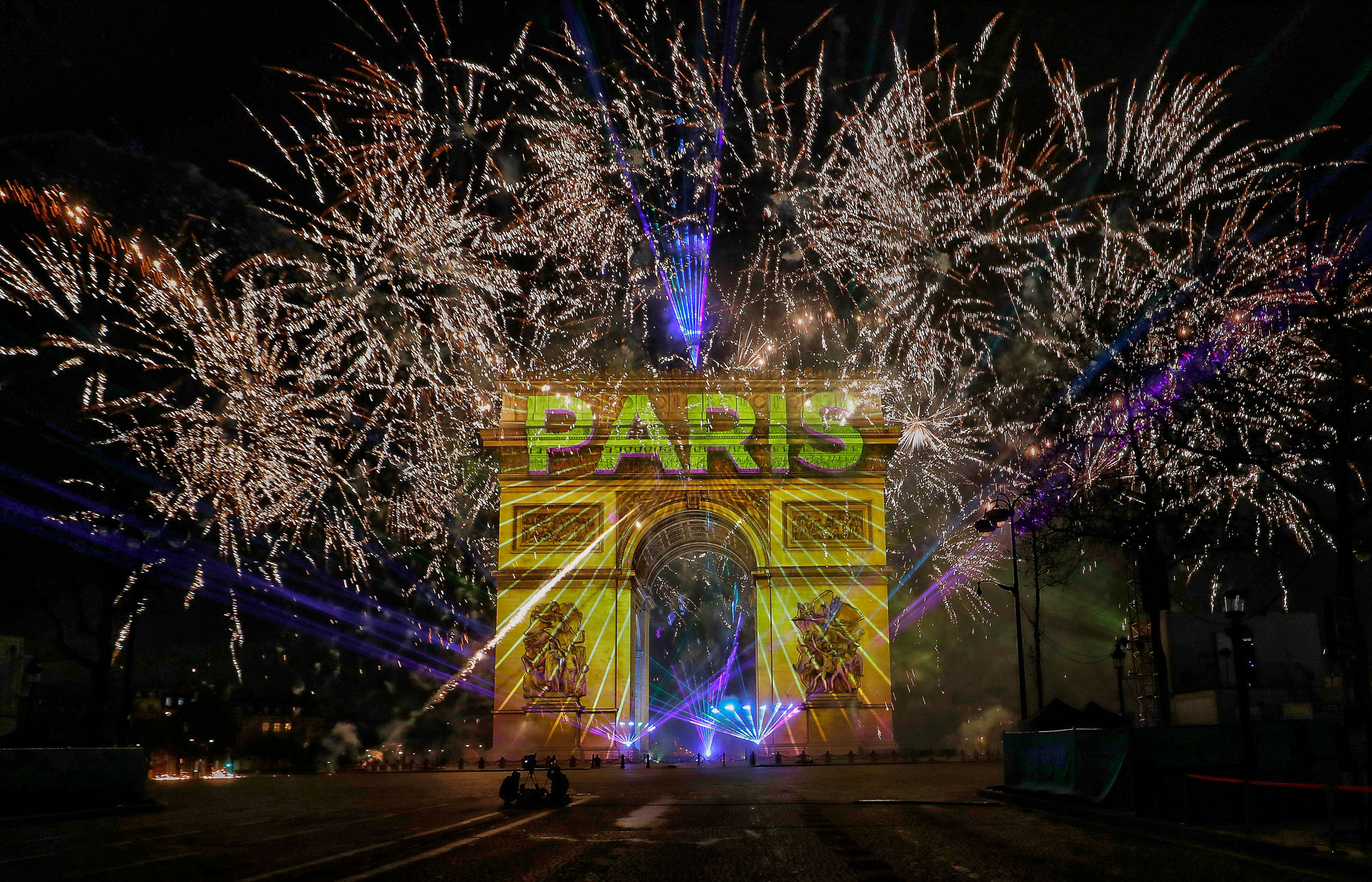 Fireworks are ignited as 'Paris 2020' is projected onto the Arc de Triomphe during the New Year's Celebration on the Champs-Elysees on December 31, 2019, in Paris.
