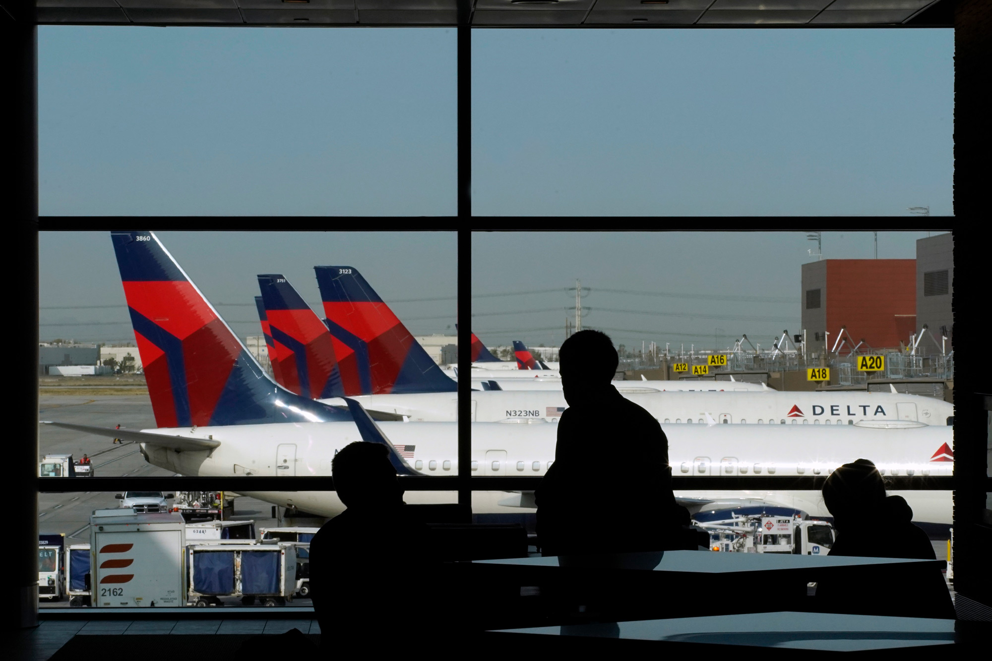 Travelers wait for flights as Delta Air Lines planes sit at gates at the Salt Lake City International Airport in Salt Lake City, Utah, on September 15.
