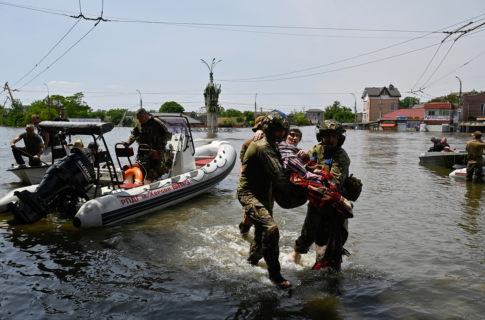 Ukrainian military personnel help an elderly woman to evacuate from a flooded area of Kherson on June 8.