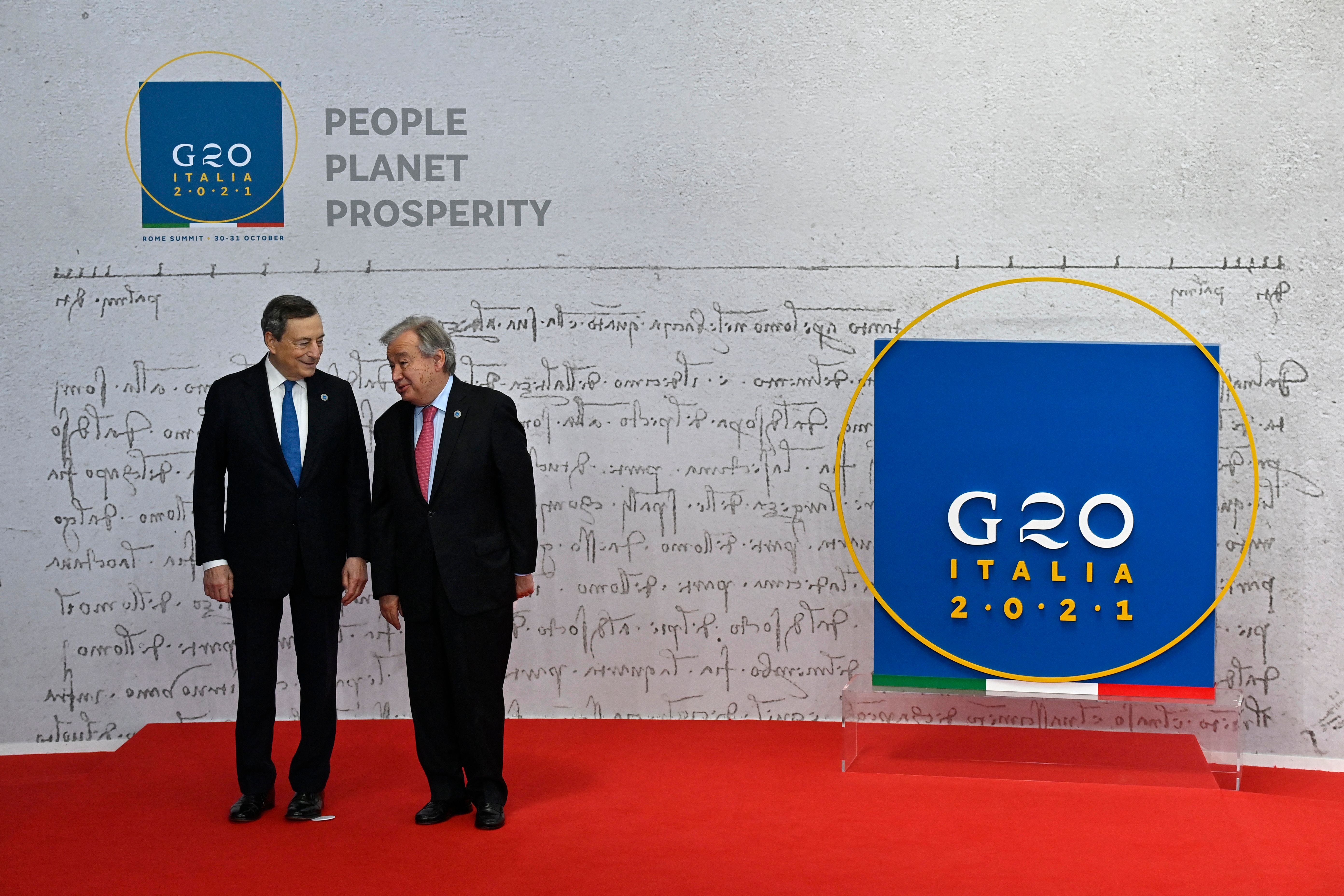 Italy's Prime Minister Mario Draghi, left, greets United Nations Secretary-General Antonio Guterres, Saturday, October 30, 2021.