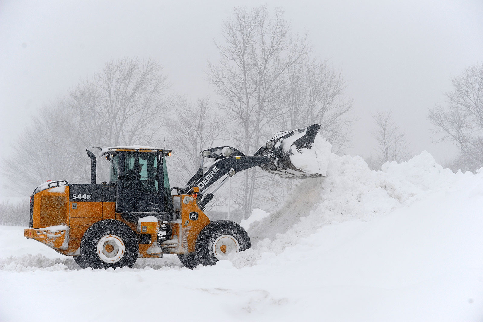 A loader clears snow from a parking lot in Hamburg, New York, on November 18. 