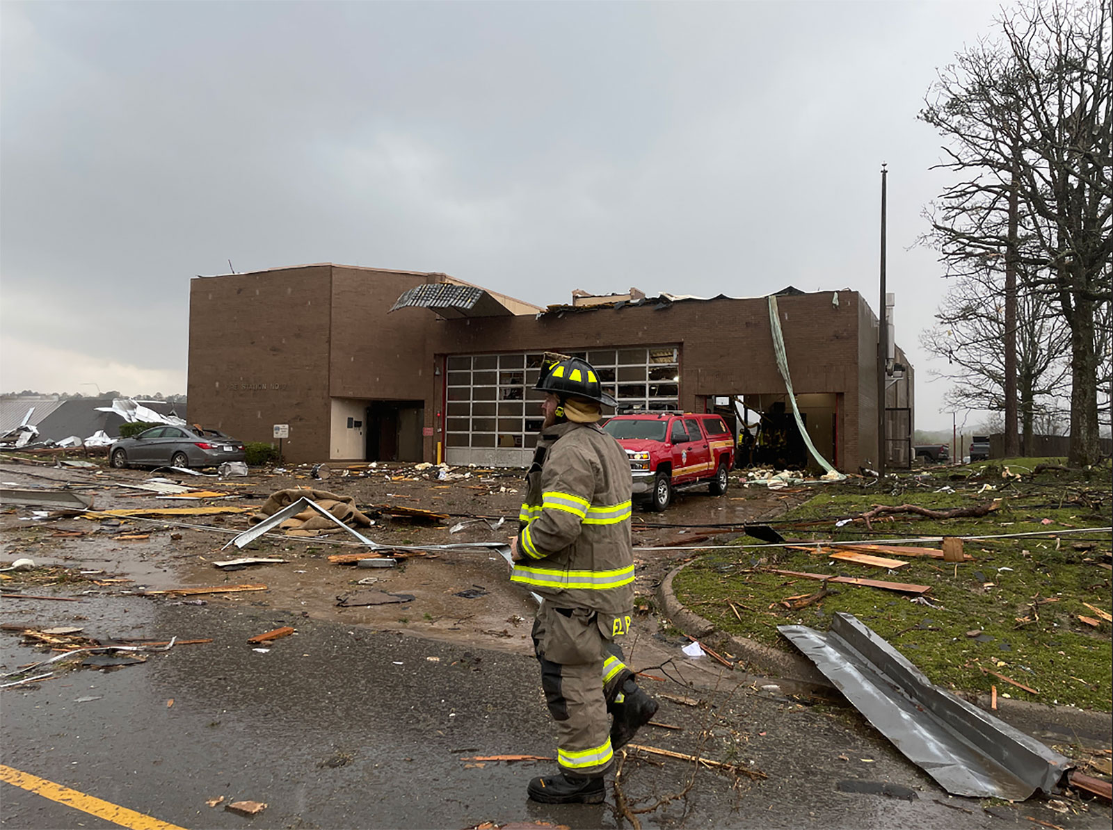 A firefighter walks by a damaged fire station due to a storm in Little Rock on Friday. 