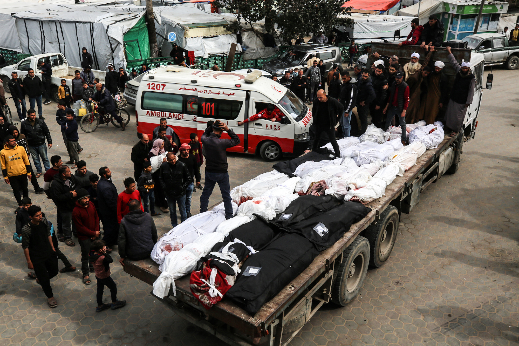 Palestinians are seen transporting the bodies during a mass funeral at the Al-Aqsa hospital in Gaza on March 16.