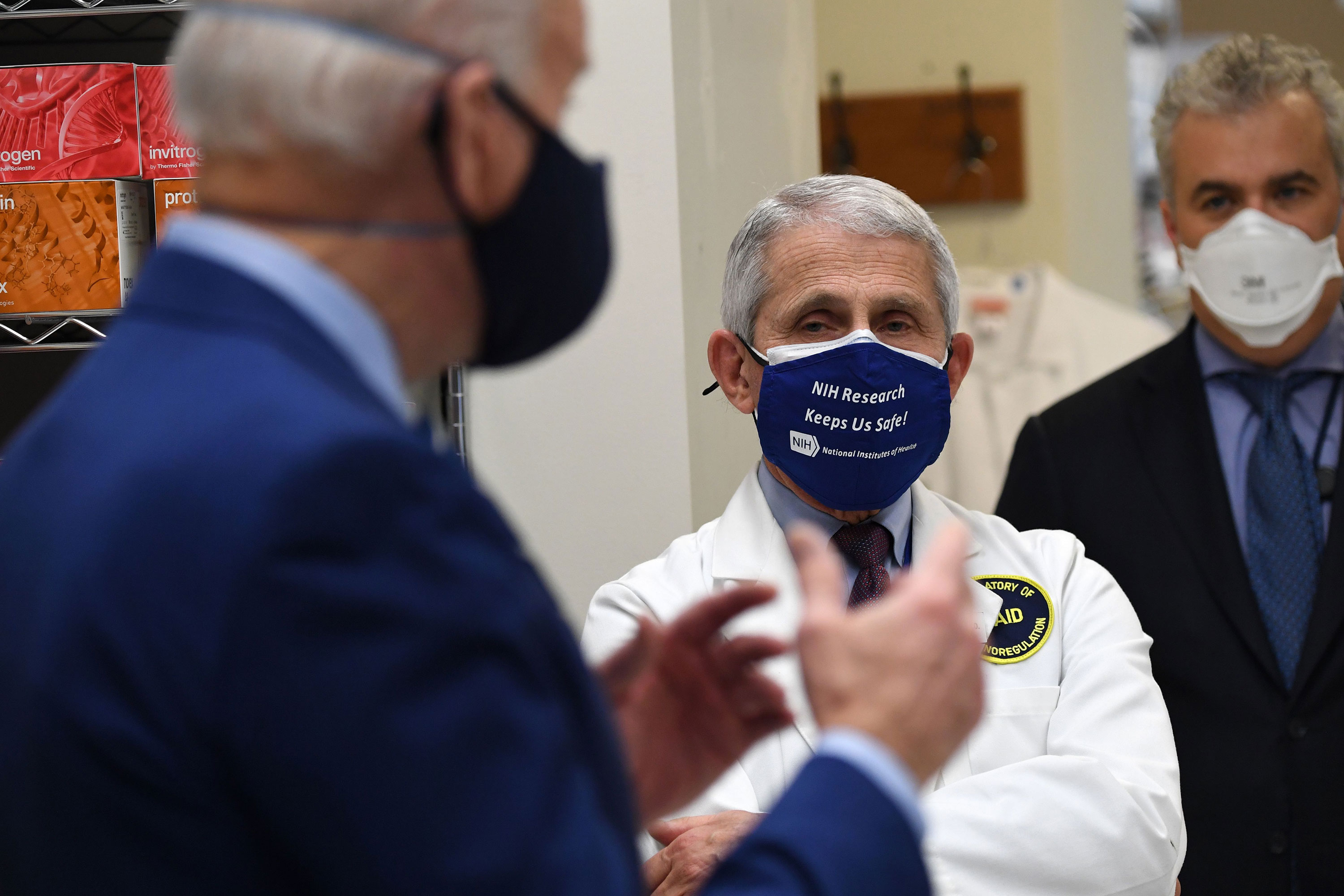 Dr. Anthony Fauci listens as President Joe Biden speaks during a tour of the Viral Pathogenesis Laboratory at the National Institutes of Health in Bethesda, Maryland, on February 11.