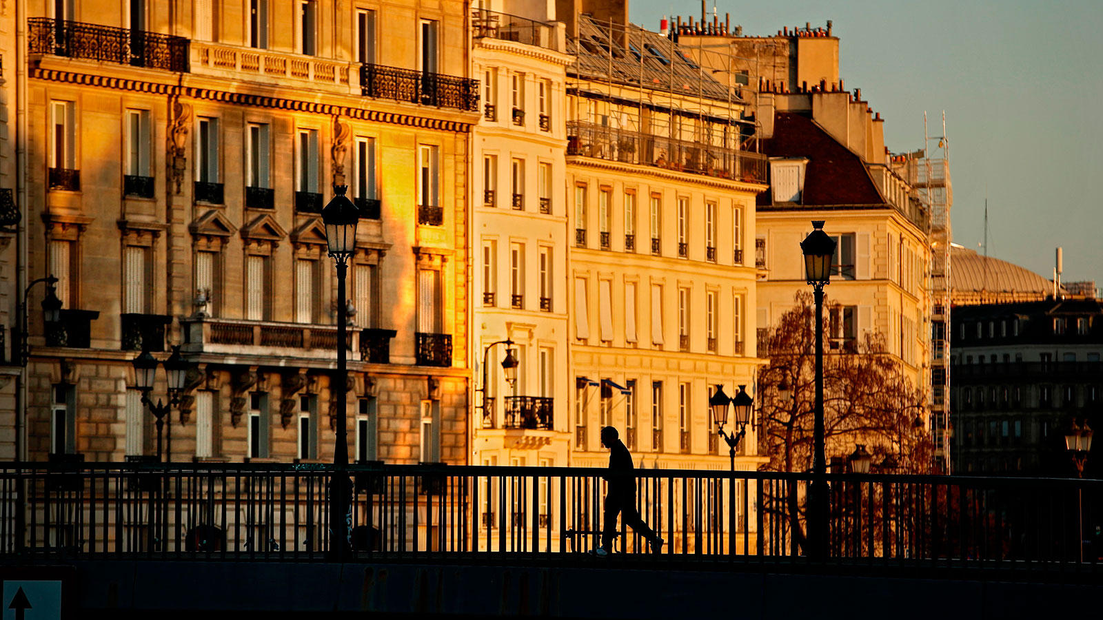 A runner cross a bridge in the early morning in Paris on April 14.