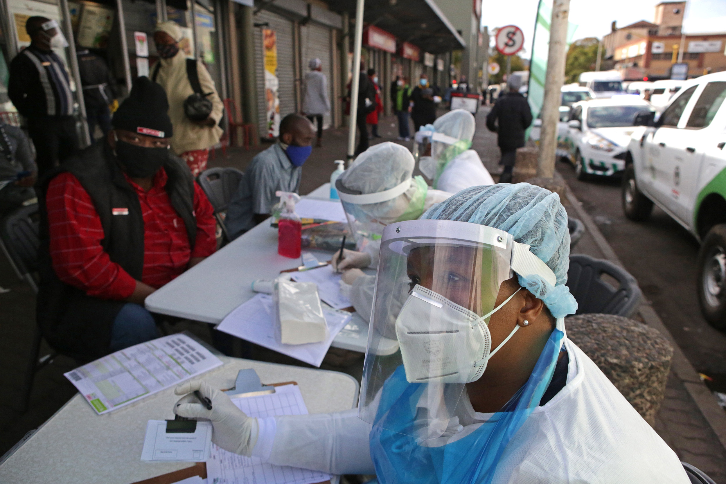 A City of Tshwane Health official looks on as she conducts a screening exercise on a taxi operator before testing for COVID-19 at the Bloed Street Mall in Pretoria, South Africa, on June 11.
