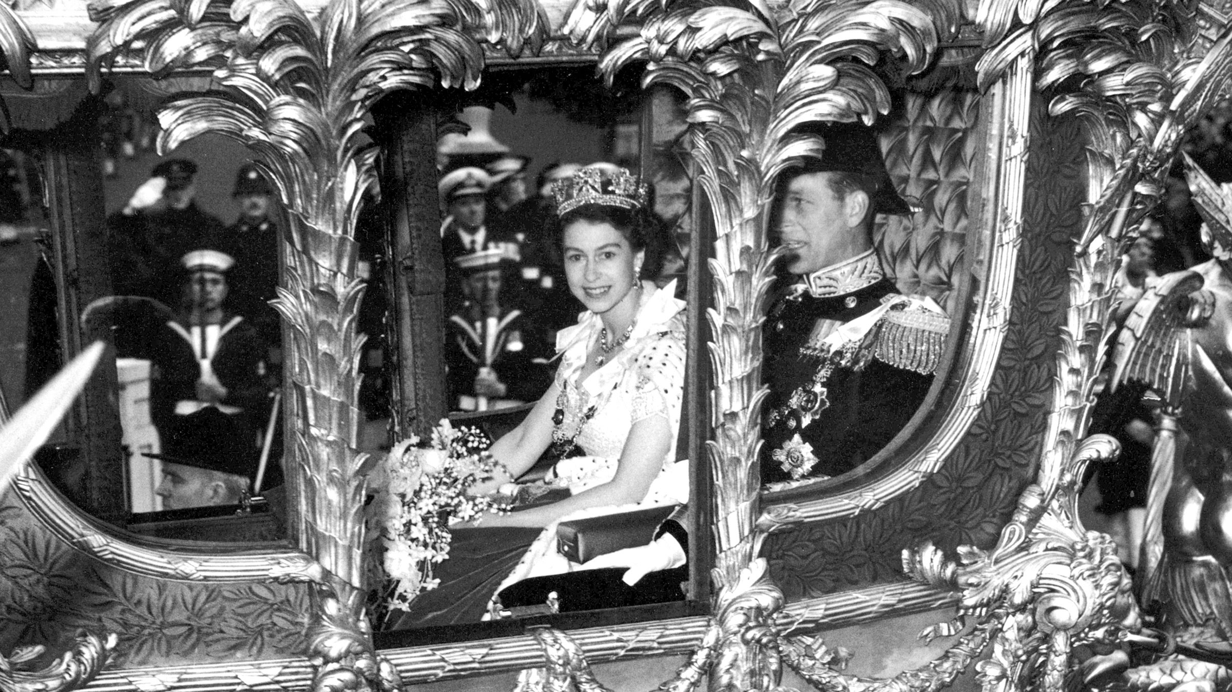 Britain's Queen Elizabeth II — with her husband, Philip — travels to her coronation ceremony in London on June 2, 1953. She ascended to the throne a year earlier, when her father died of lung cancer in February 1952. She was 25 at the time.