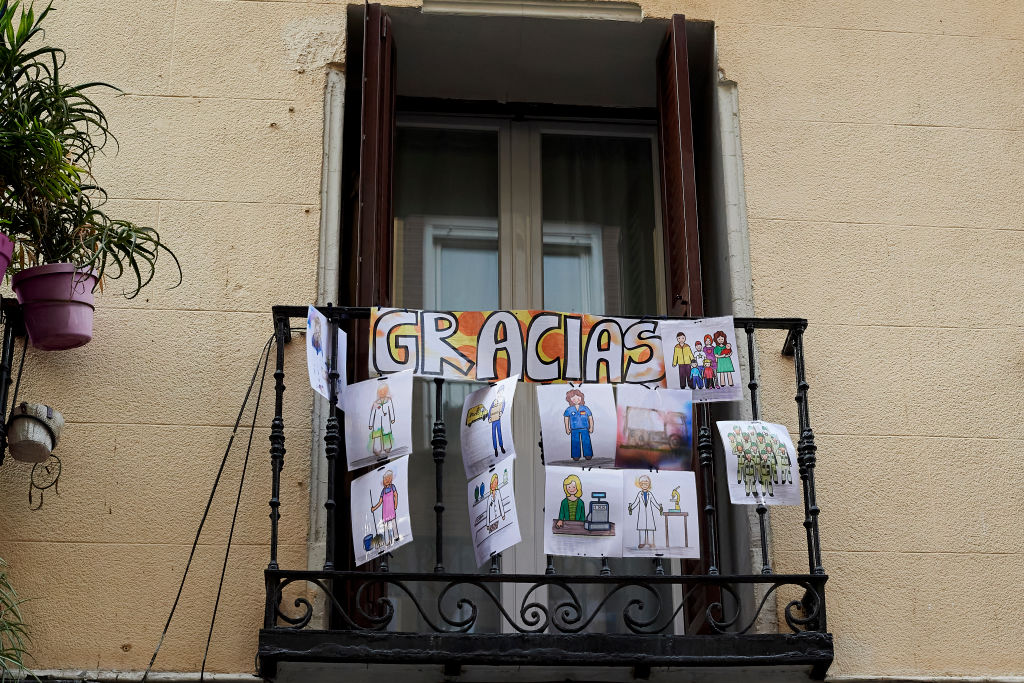 A banner that says "thank you" and pictures of key workers are displayed on a balcony on April 17 in Madrid.