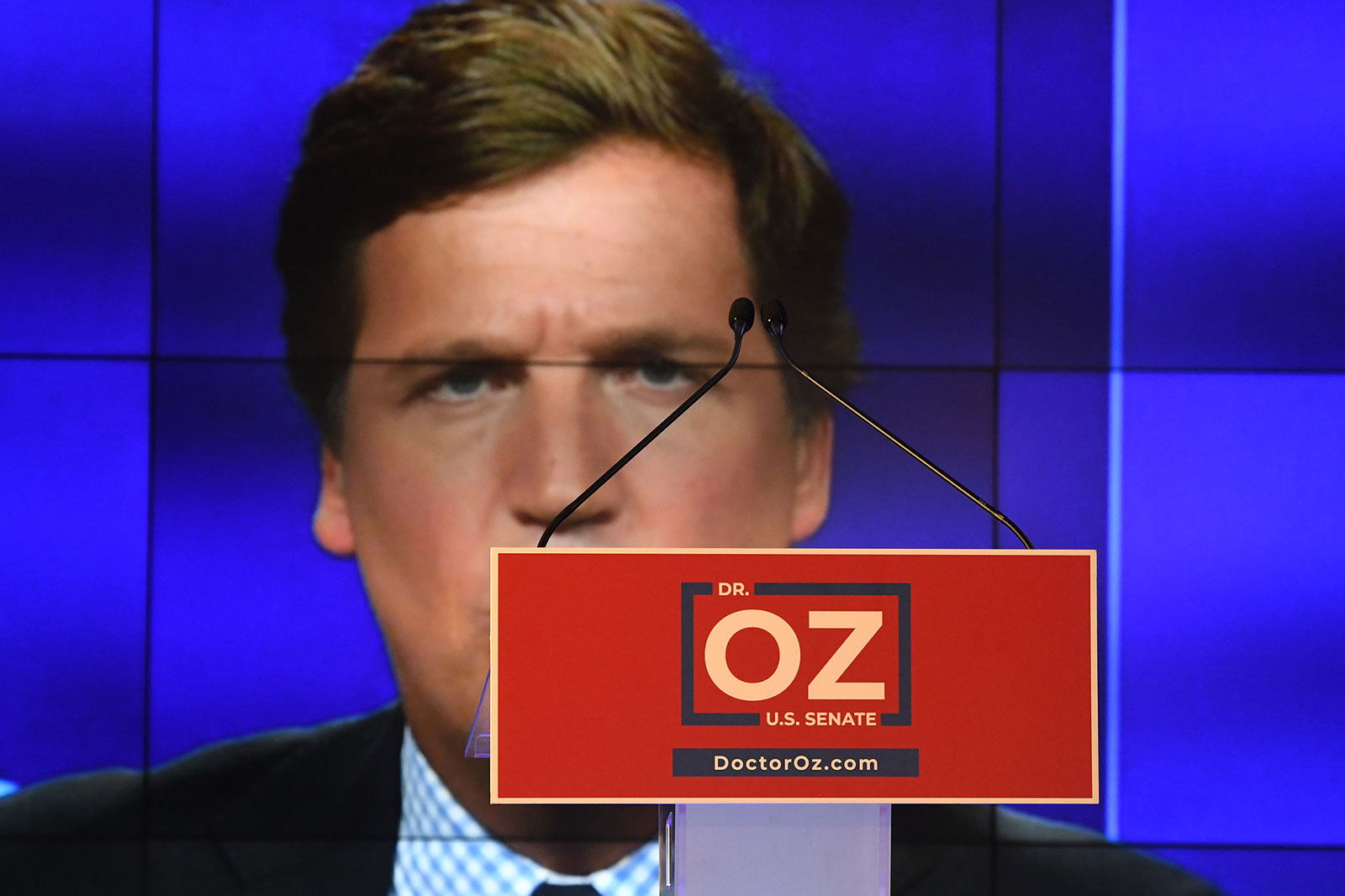 Fox News host Tucker Carlson is displayed behind the podium at an election night party for Mehmet Oz on Tuesday.