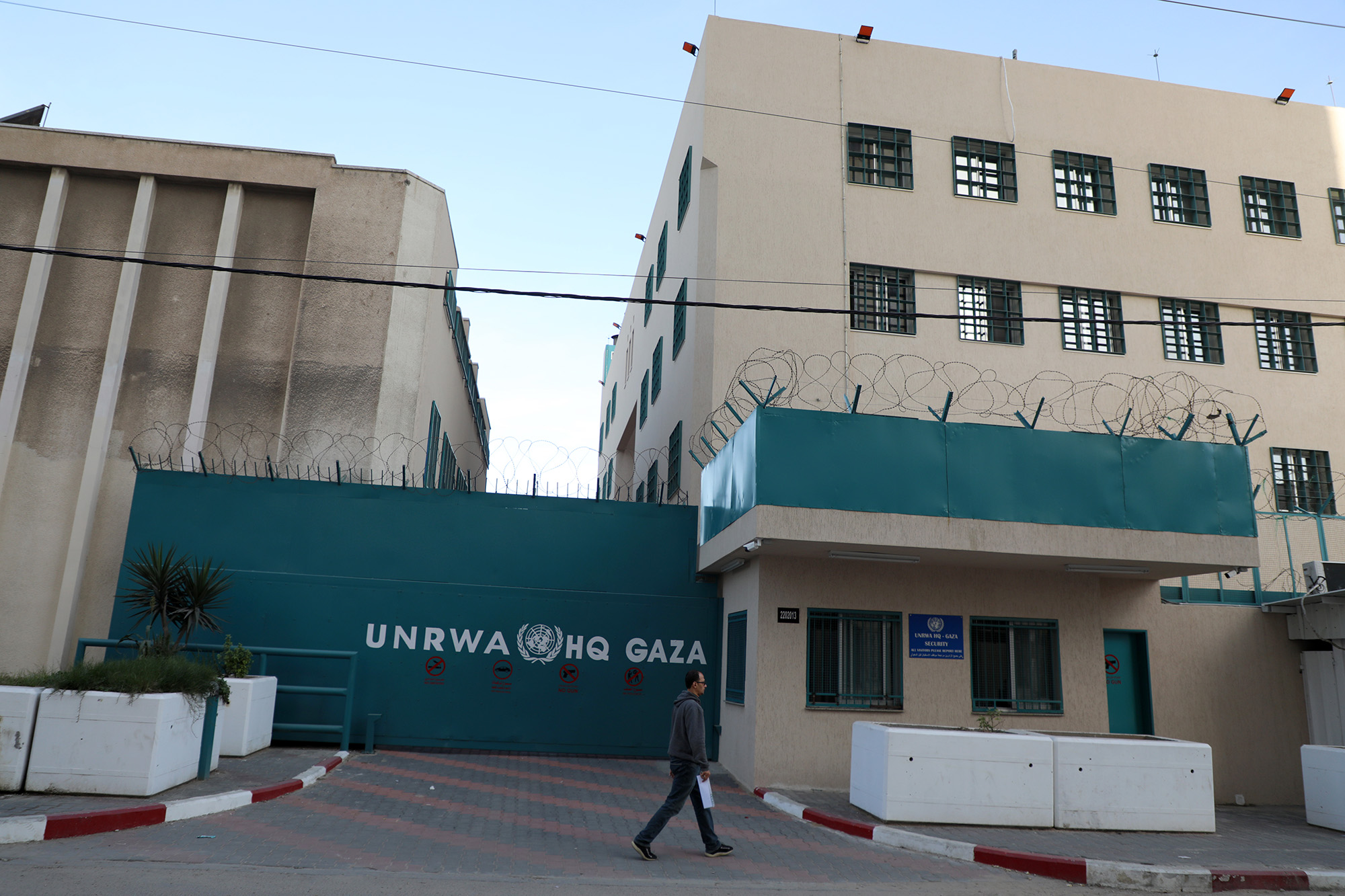A Palestinian man walks past the shuttered headquarters of the United Nations Relief and Works Agency for Refugees (UNRWA) in Gaza on November 29, 2021. 