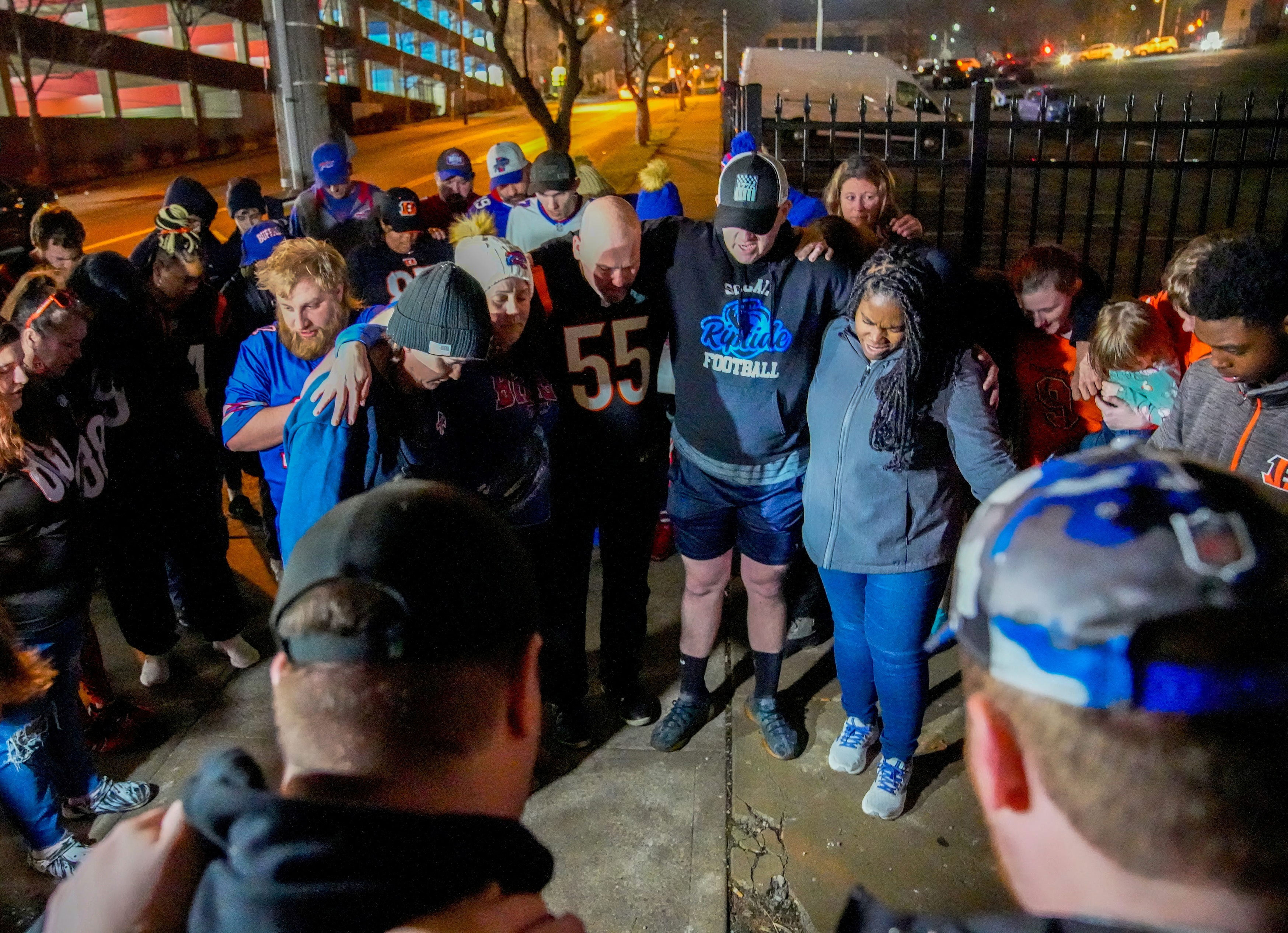 Football fans pray outside the University of Cincinnati Medical Center where Buffalo Bills safety Damar Hamlin receives care January 2 in Cincinnati.
