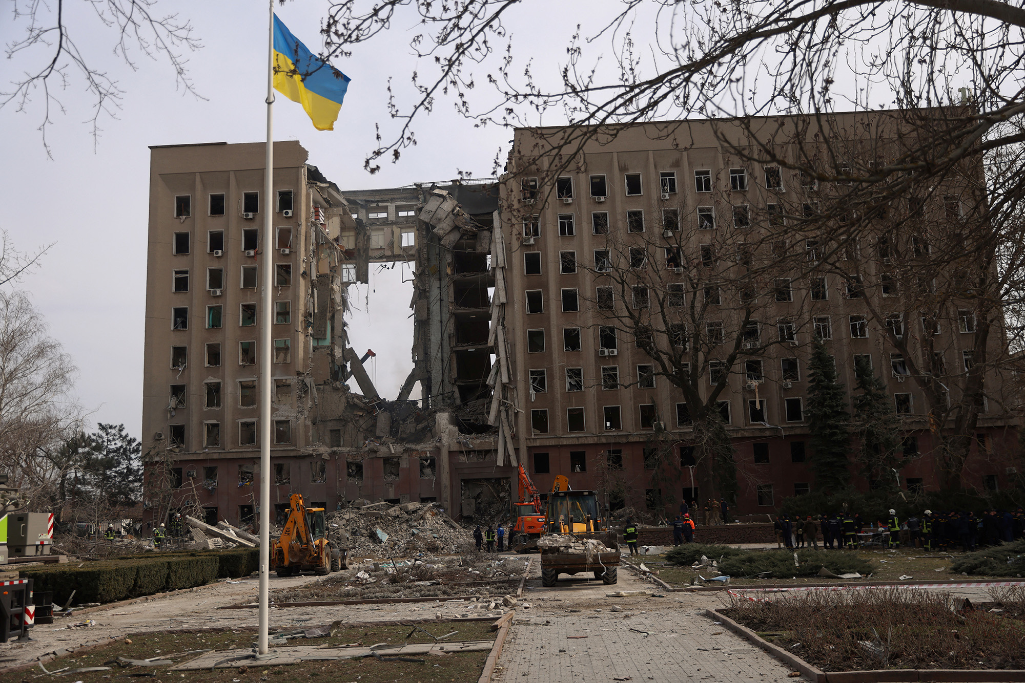 People and rescuers gather near a destroyed Ukrainian government administration building following a an attack in Mykolaiv, Ukraine, on March 29.