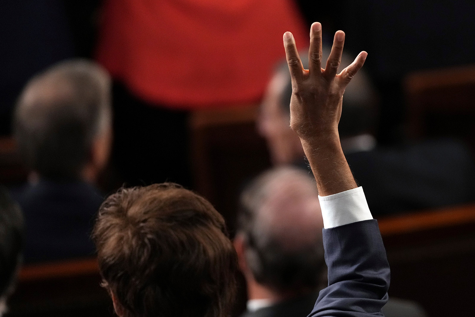 A Congress member holds up four fingers as Biden speaks, calling for four more years of his presidency.