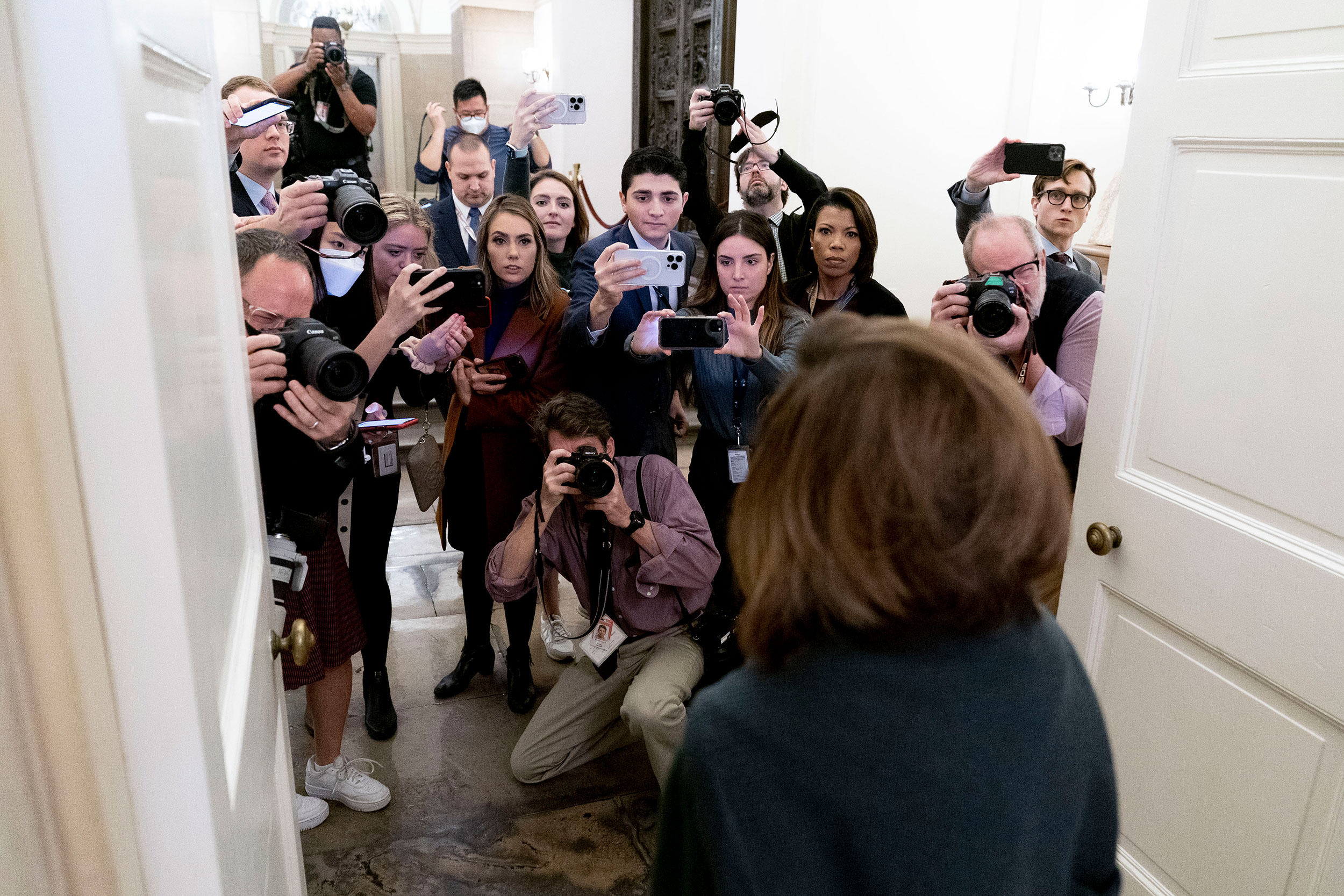 Former House Speaker Nancy Pelosi, seen in the foreground, talks to reporters as she arrives at the Capitol on Wednesday.