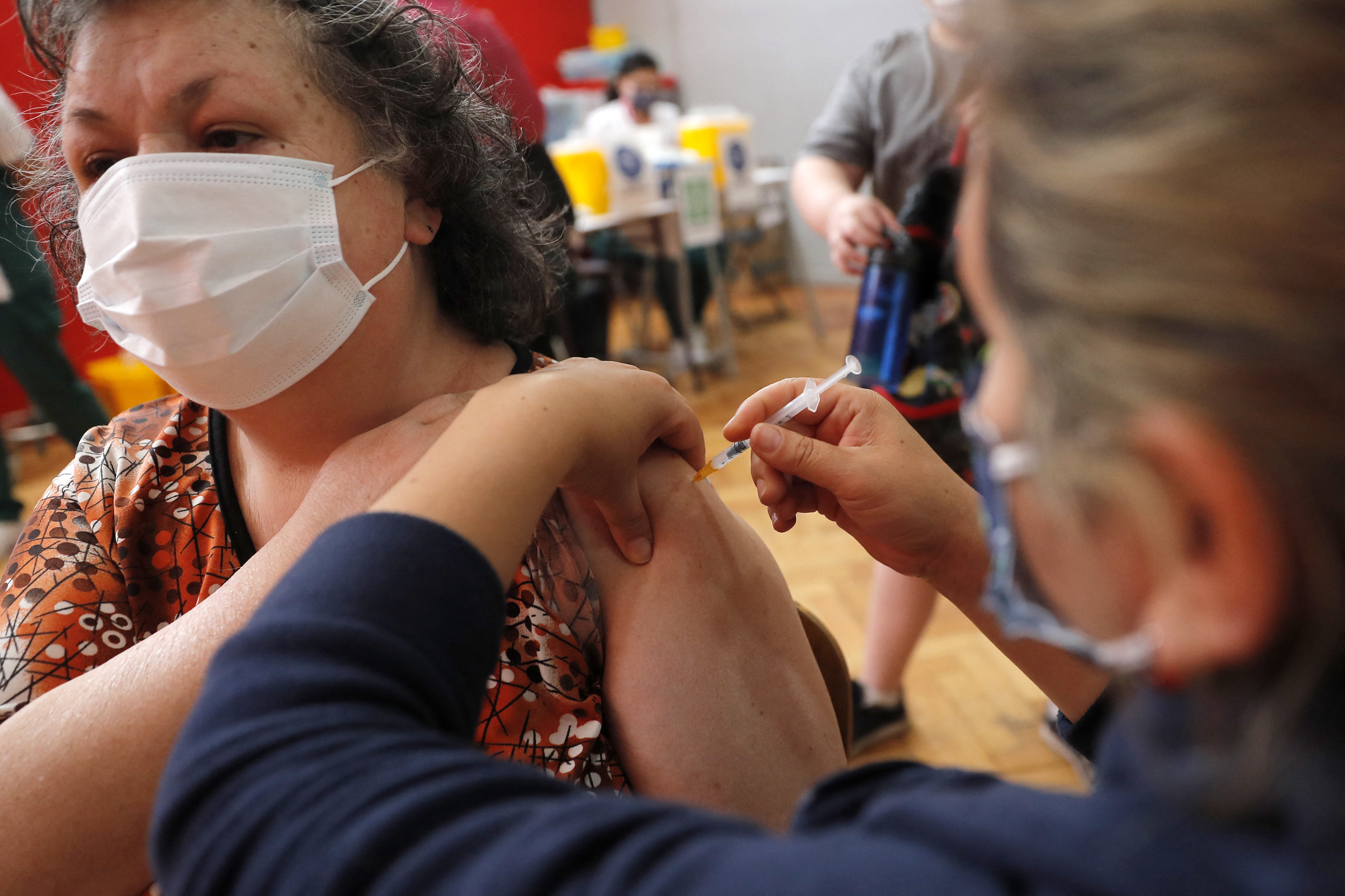 A woman receives a dose of the Pfizer-BioNTech vaccine against COVID-19 at a vaccination centre in Santiago, on December 23, 2021. 