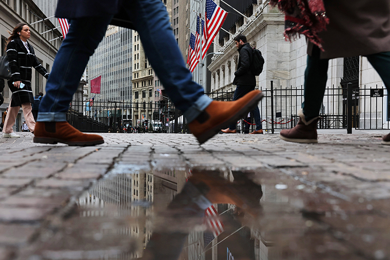 People walk past the New York Stock Exchange on January 26 in New York City. 
