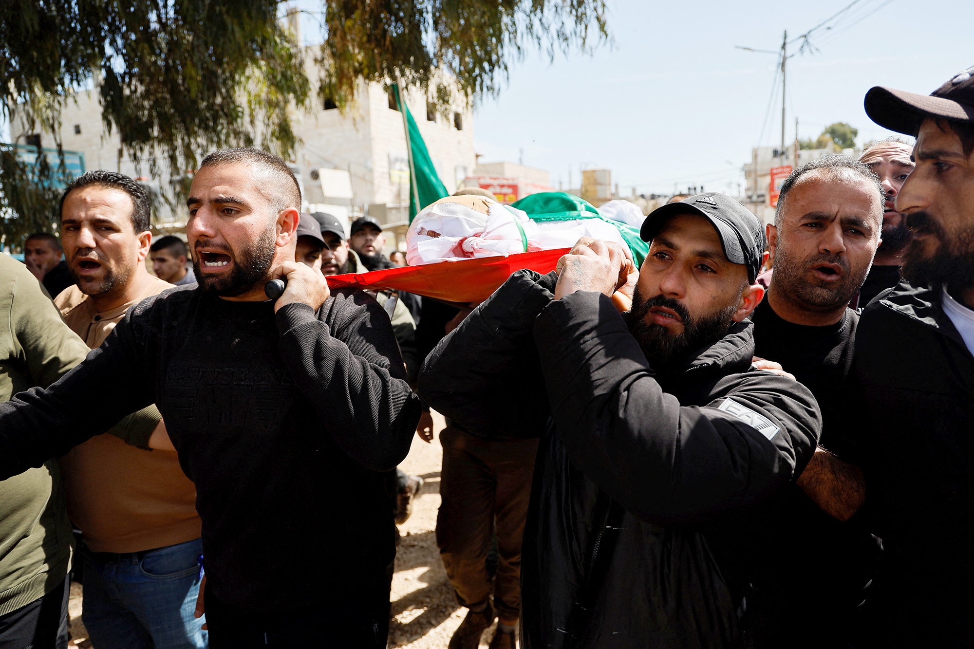 Mourners carry the body of one of two Palestinians who were killed at a yard outside a hospital during an Israeli raid in the Israeli-occupied West Bank, on March 13.