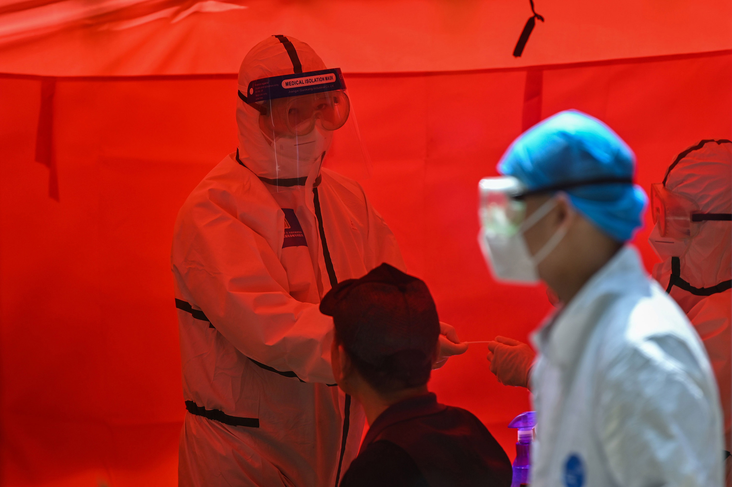 A medical worker takes a swab sample from a man to be tested for the coronavirus in Wuhan, China, on Tuesday, May 19. 