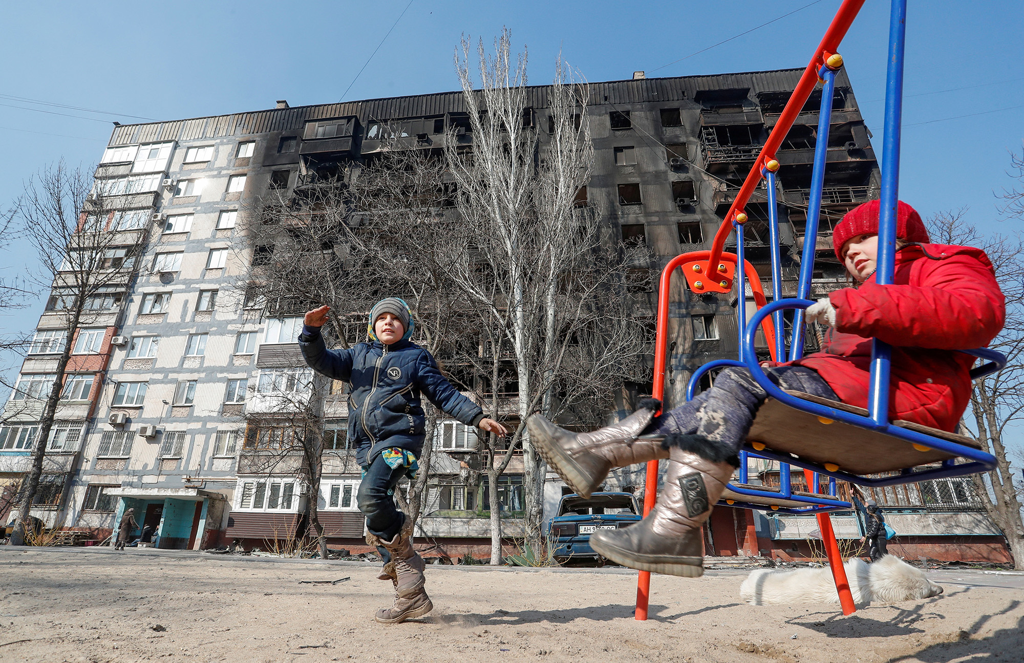 Children play in front of a damaged building in the southern port of Mariupol, Ukraine, on March 23.