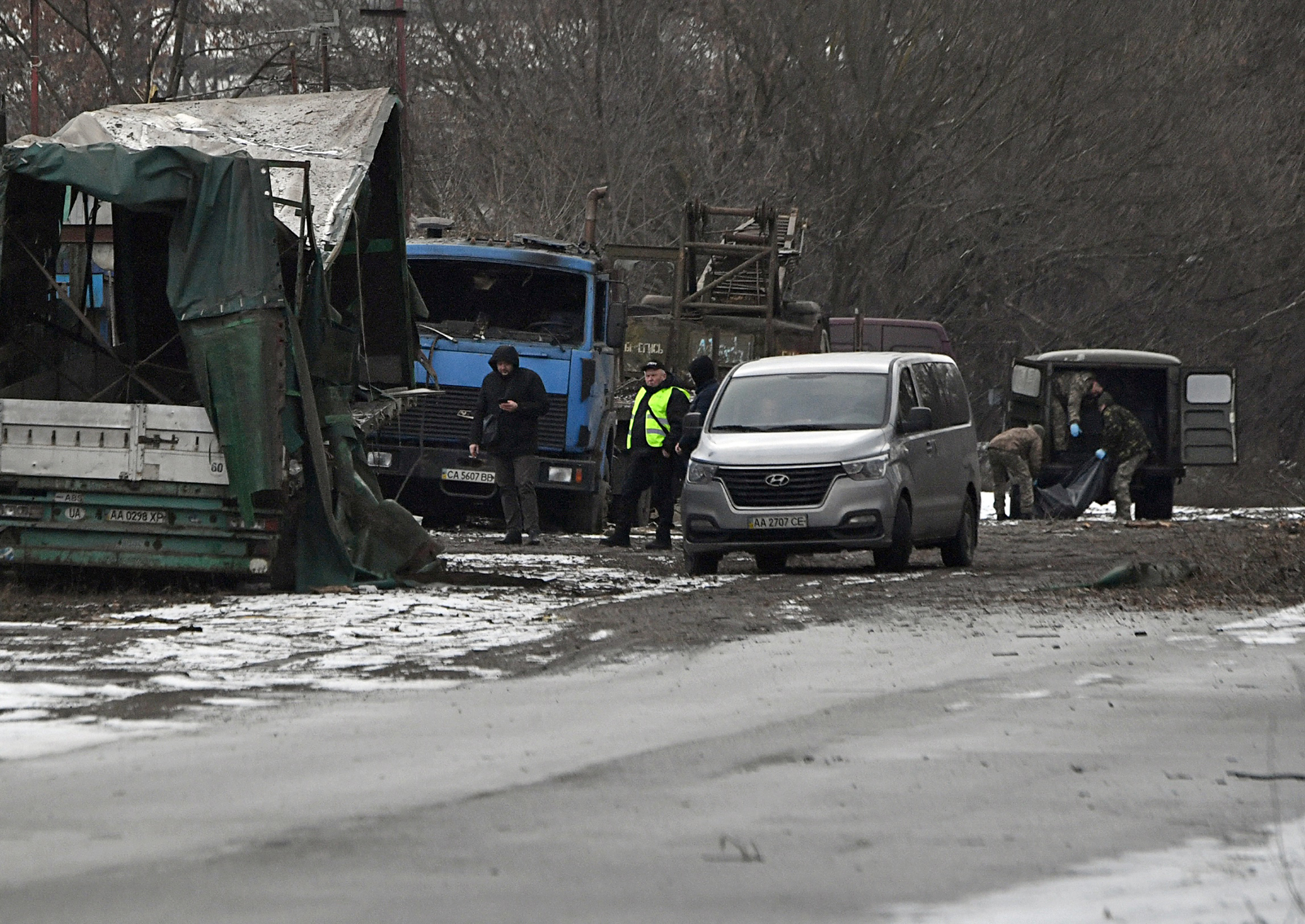 Policemen load the body of a civilian into a car following Russian missile strike on the industrial zone of Kyiv on January 26.