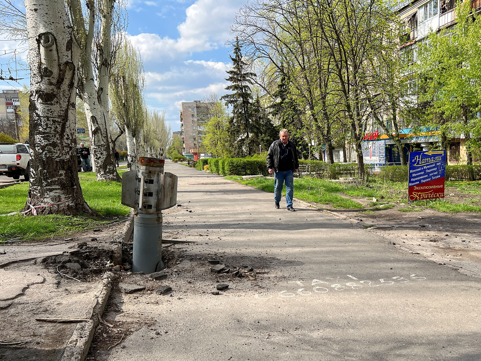 A man walks past a missile that lodged in the ground in Rubizhne in the Luhansk region of Ukraine, on April 21.