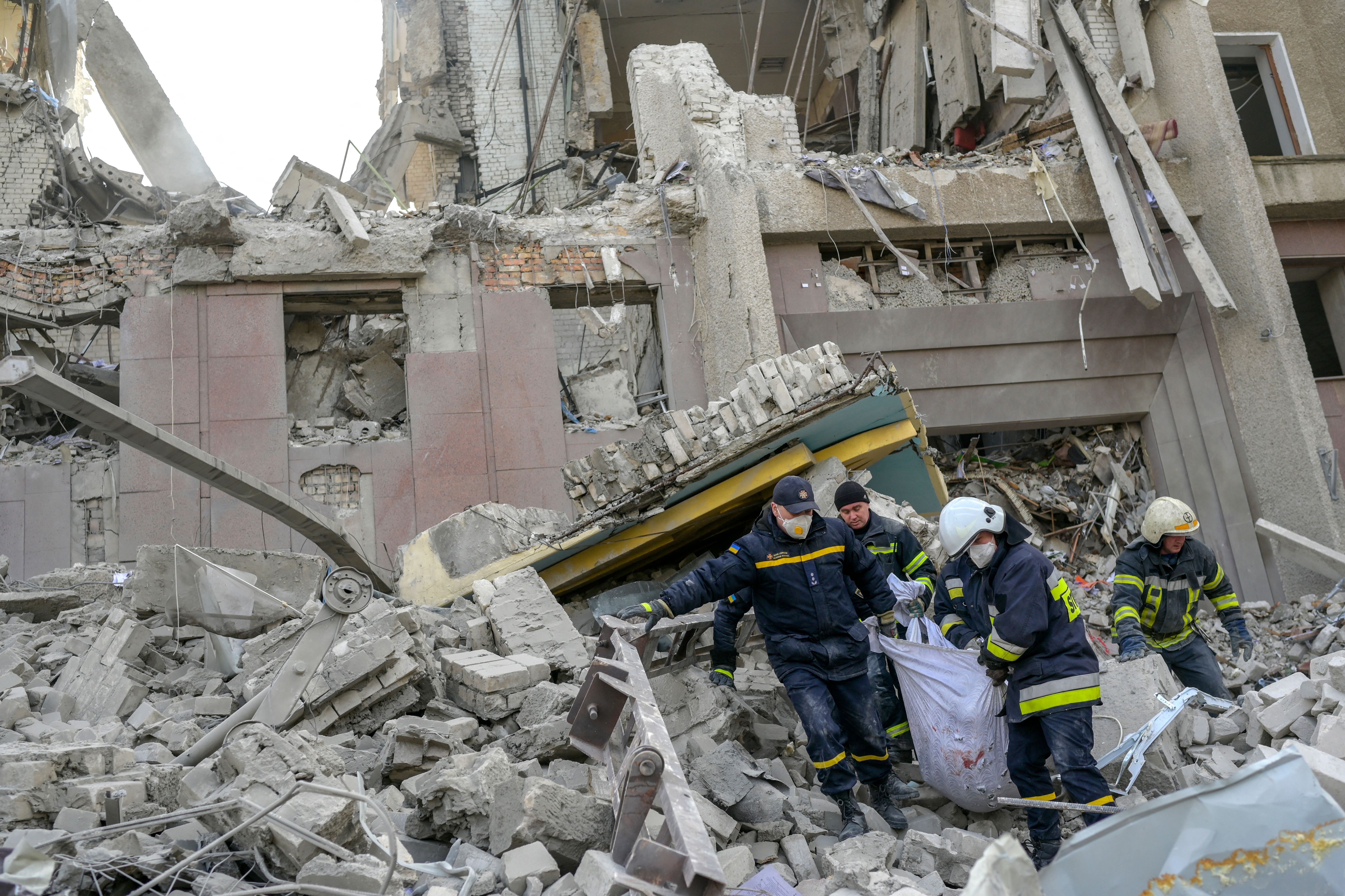 Firefighters carry a dead body from the rubble of a government building hit by Russian rockets in Mykolaiv, Ukraine, on March 29.