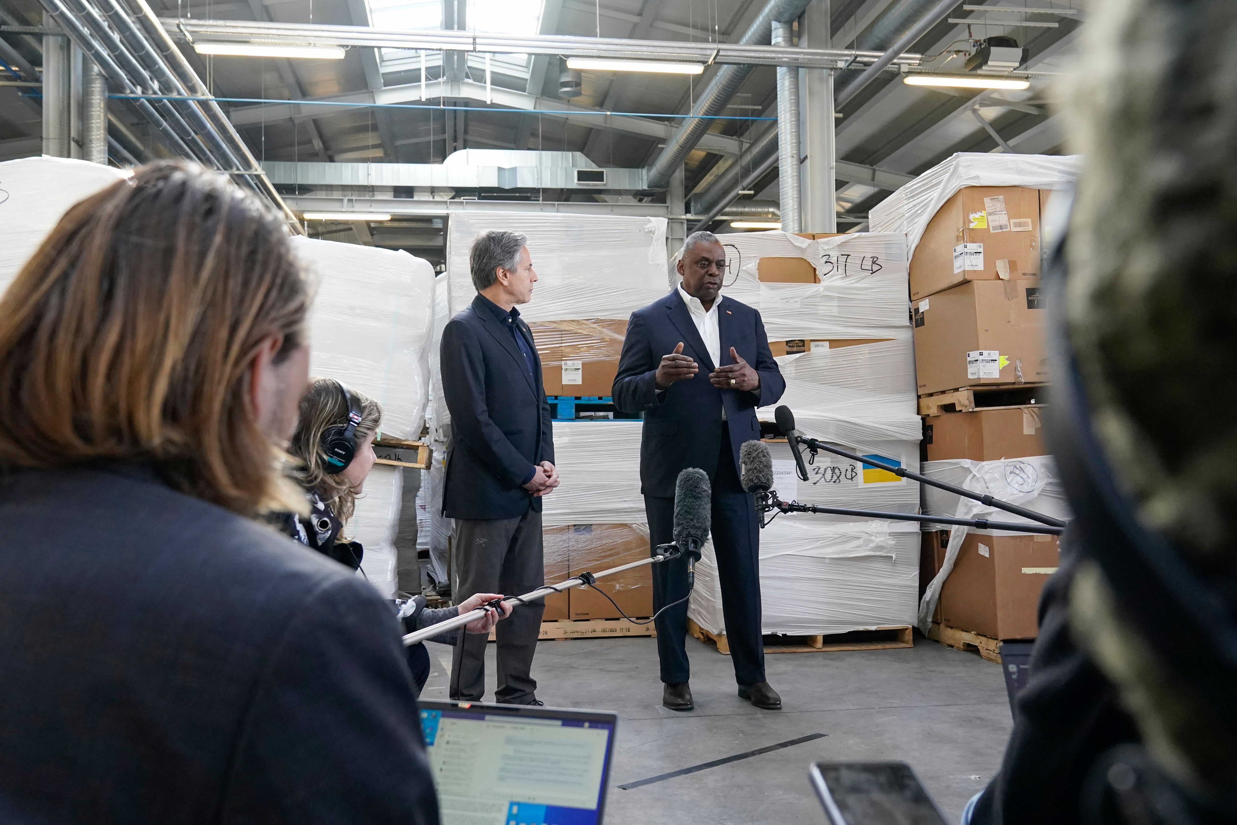 Pallets of aid to Ukraine are stacked behind Secretary of Defense Lloyd Austin, right, and Secretary of State Antony Blinken as they speak with reporters on April 25, in Poland near the Ukraine border. 