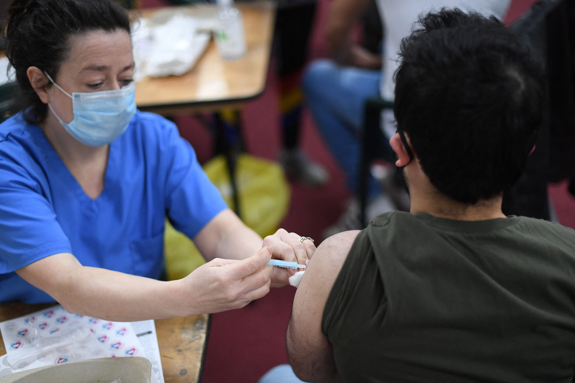 A health worker administers a dose of the AstraZeneca vaccine in London, on Tuesday, March 23. 
