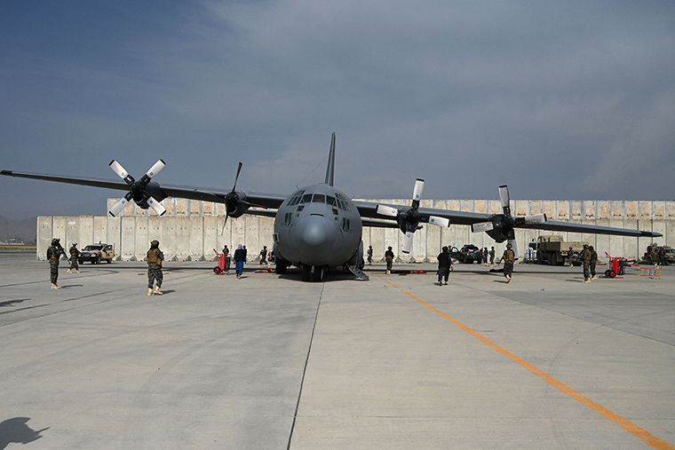 Taliban fighters stand guard next to an Afghan Air Force aircraft at the airport in Kabul on August 31, following the US withdrawal from Afghanistan.