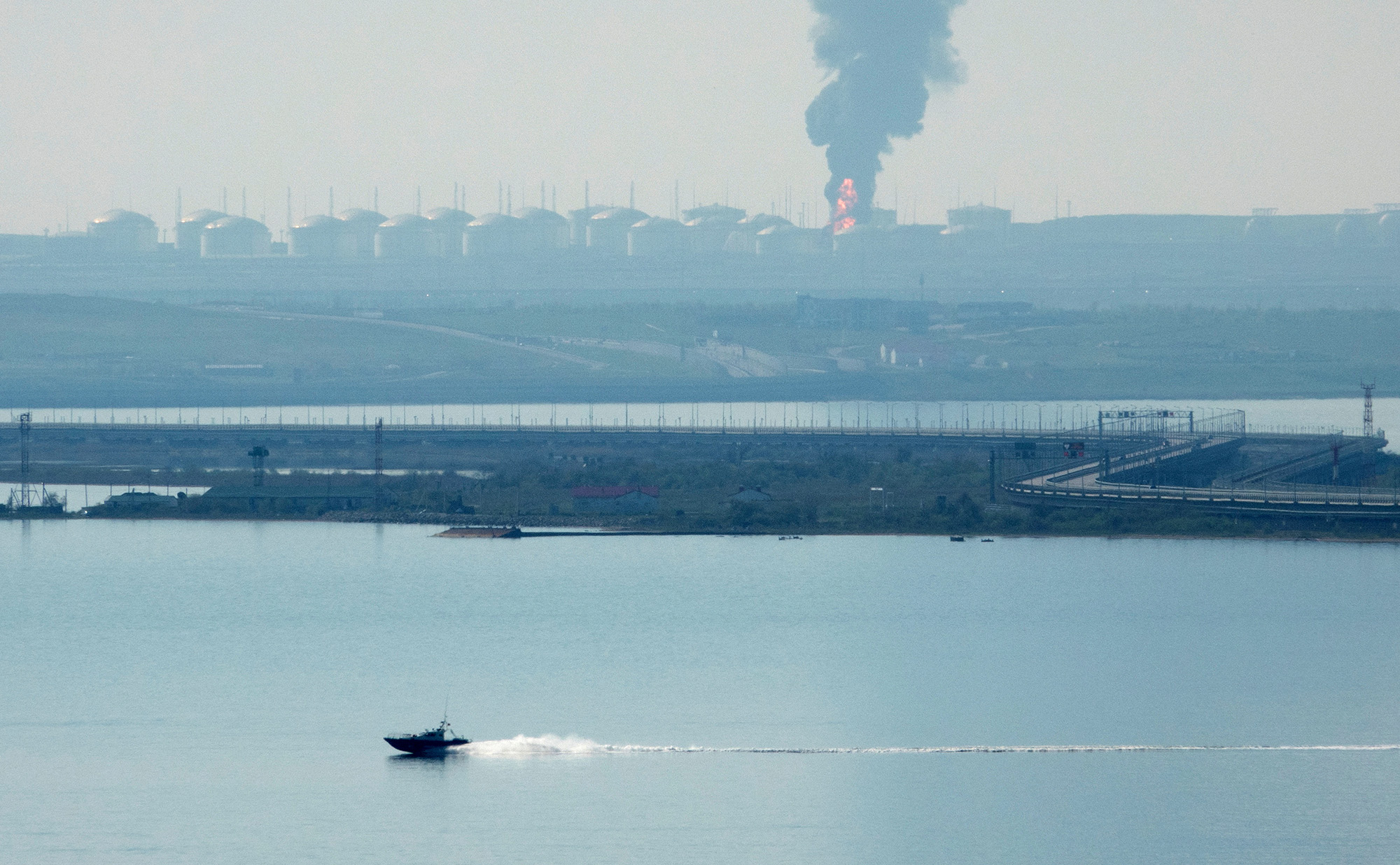A view across the Kerch Strait shows a fuel depot on fire near the village of Volna in Russia's Krasnodar region as seen from the coastline in Crimea, on May 3.