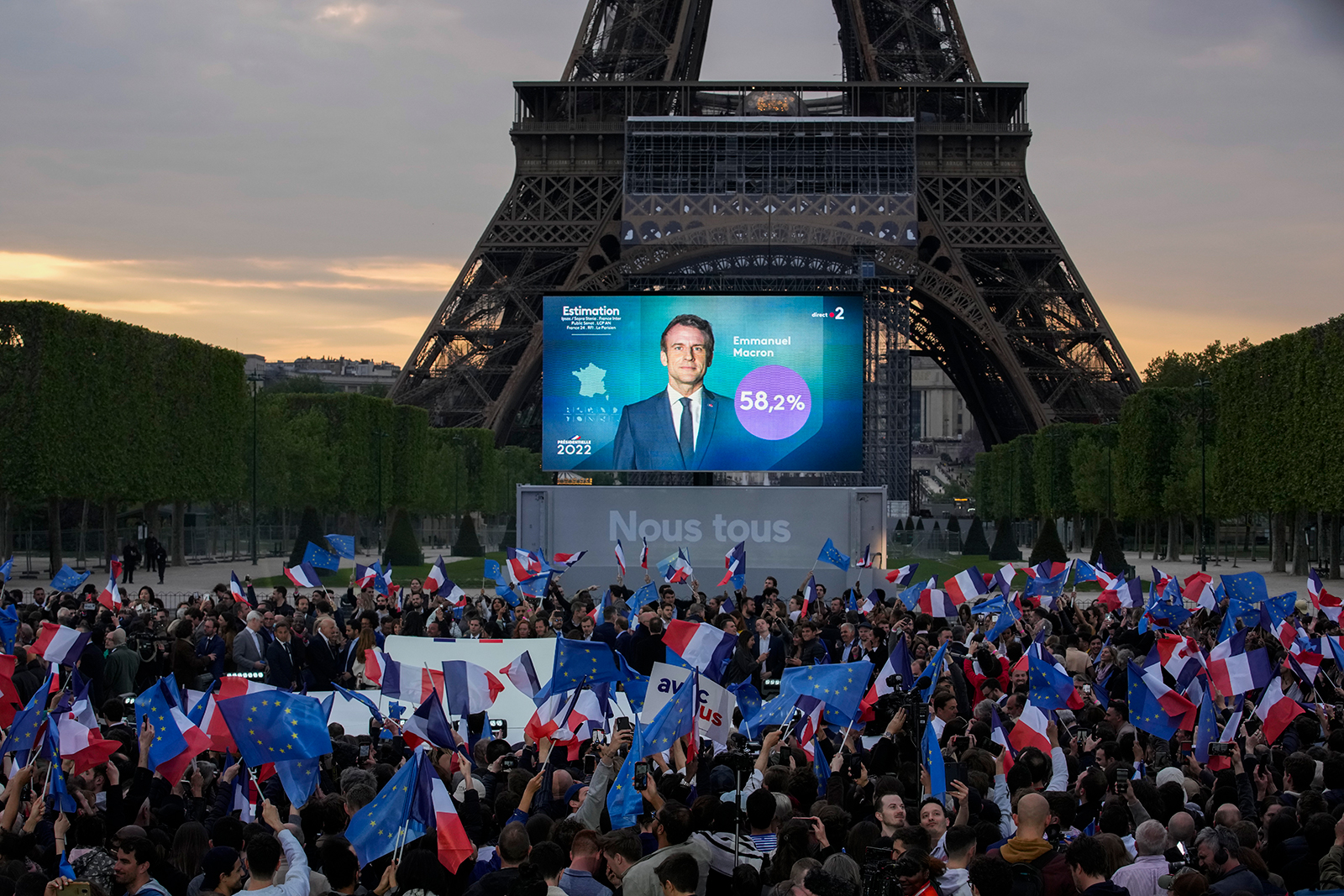Supporters of French President Emmanuel Macron watch a screen in front of the Eiffel Tower as the first election projections are announced in Paris, France, Sunday, April 24.