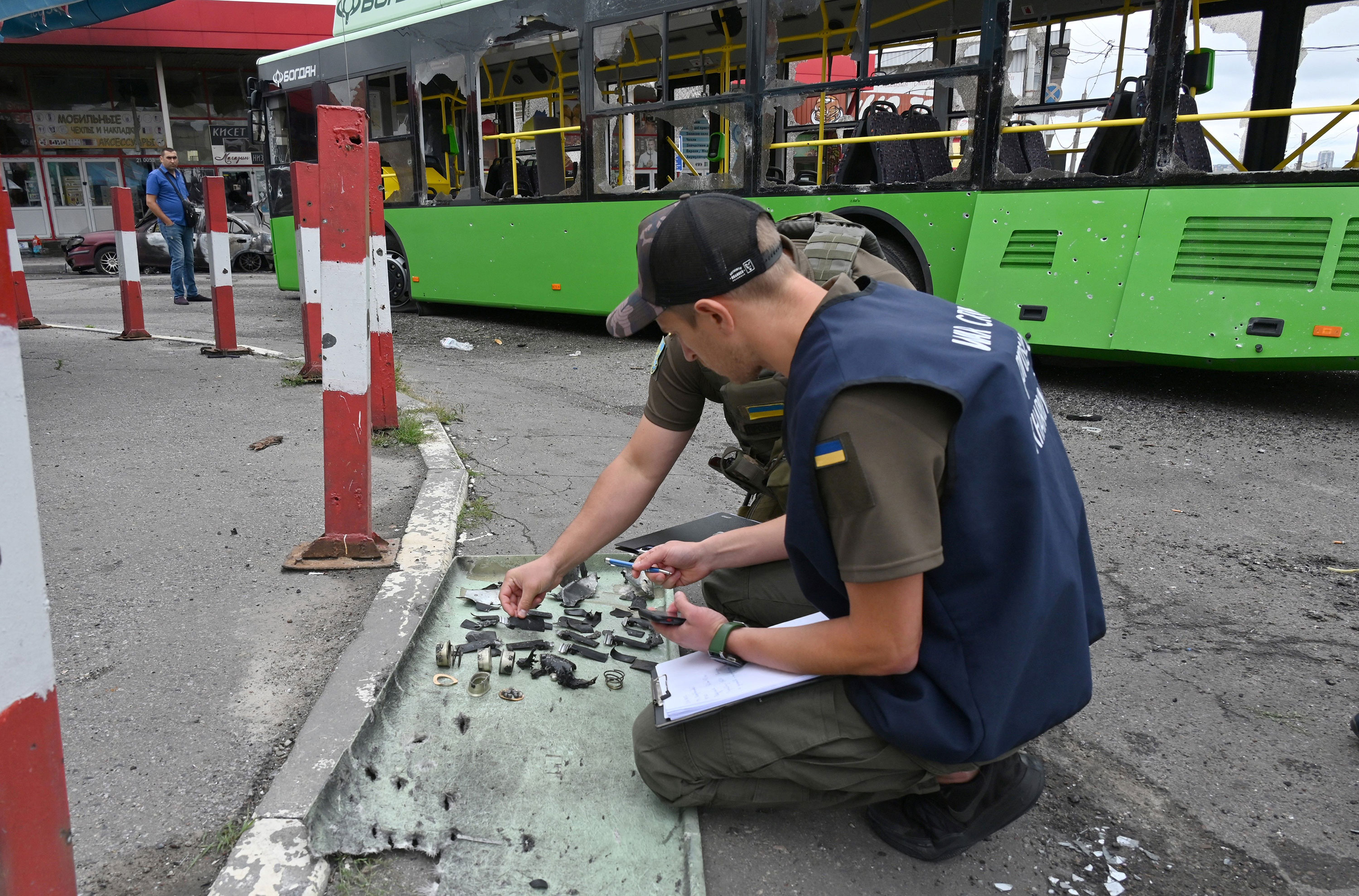 Ukrainian authorities collect fragments after a Russian rocket strike in Kharkiv, Ukraine, on Thursday.