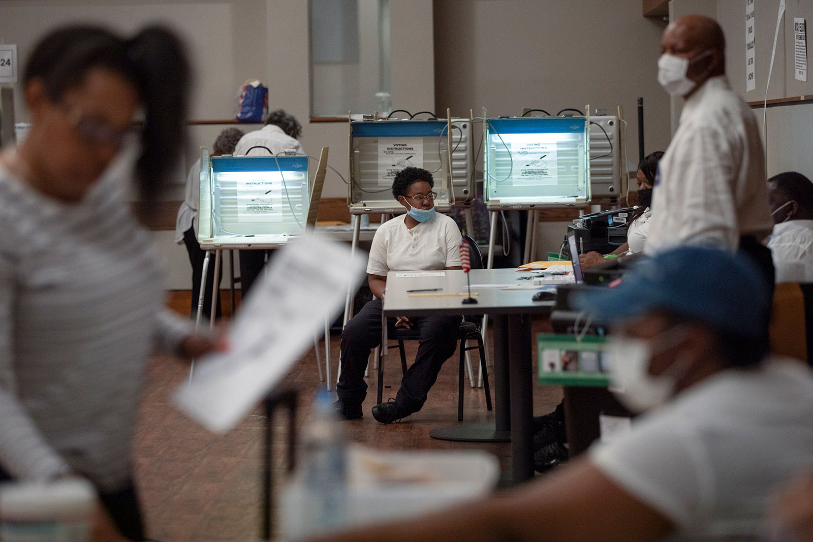 Primary election workers help voters at a polling place in Detroit on Aug. 2. 