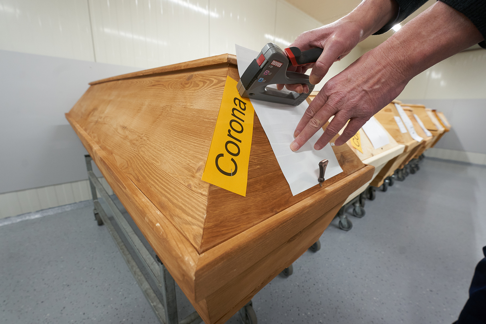 A crematorium employee affixes a "Corona" marker to a coffin in Dachsenhausen, Germany on January 22.