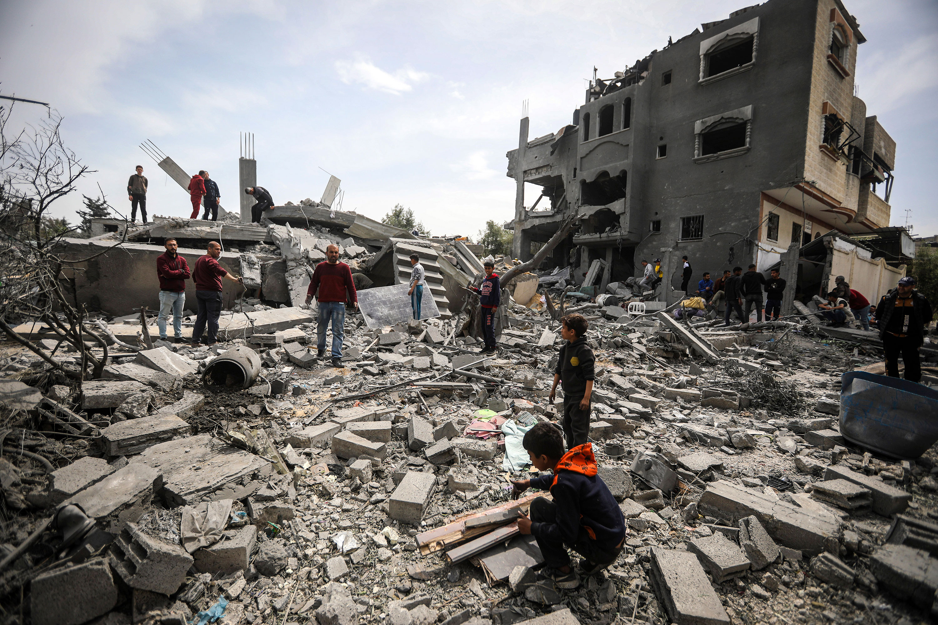 Palestinians inspect the damage to a residential building after an Israeli airstrike in the Maghazi refugee camp in central Gaza Strip on March 29. 