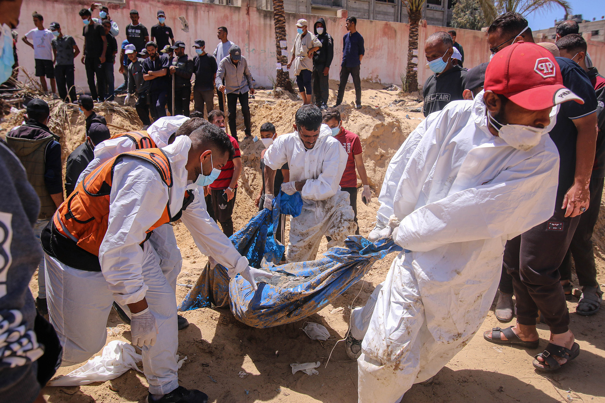 Palestinian health workers recover buried bodies from a mass grave at the Nasser Medical Hospital compound in Khan Younis, Gaza, on April 21.