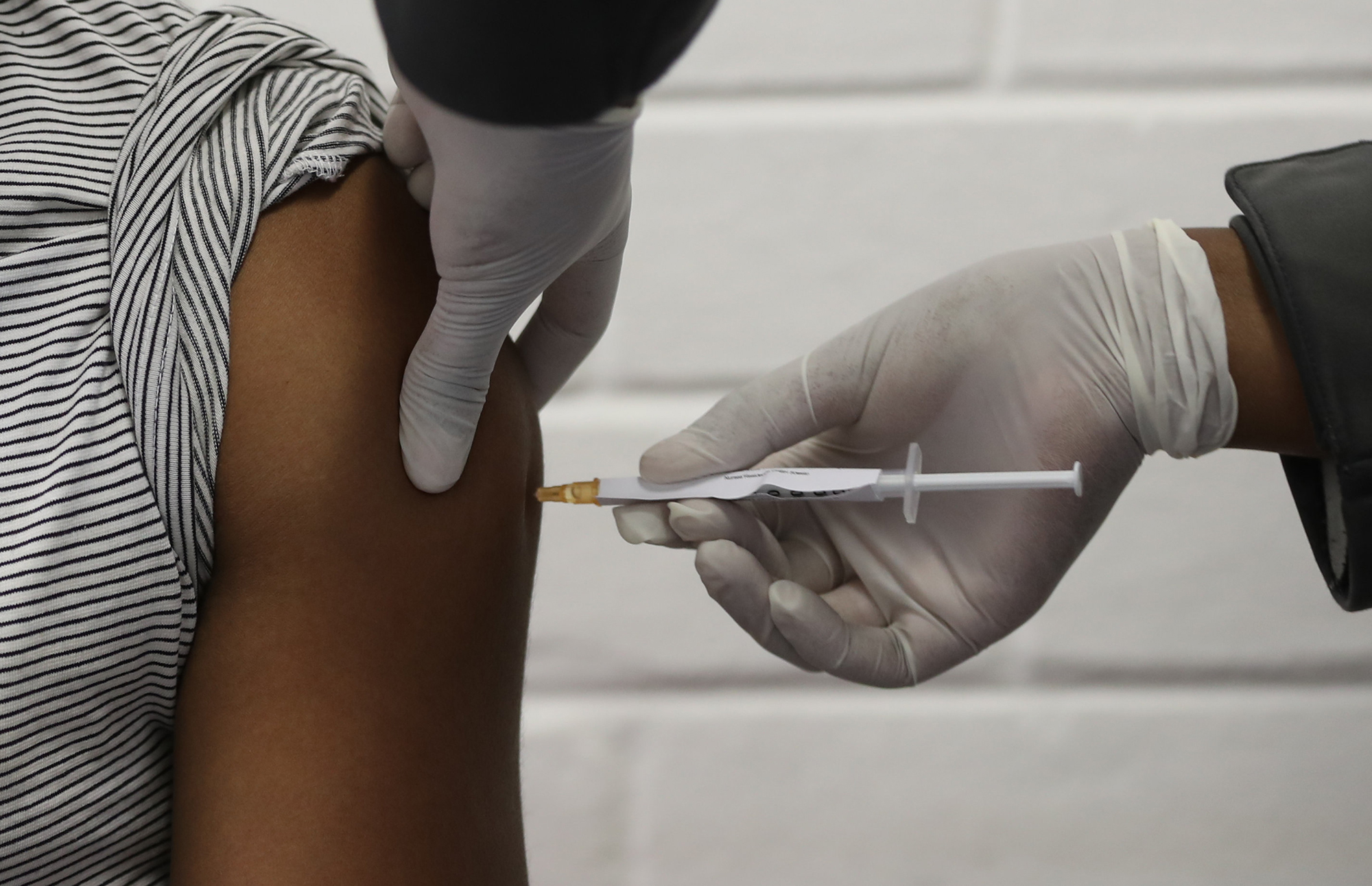 A medical worker injects a vaccine trialist with the clinical trial for a potential vaccine against the COVID-19 coronavirus at the Baragwanath hospital in Soweto, South Africa, on June 24 ,2020. 
