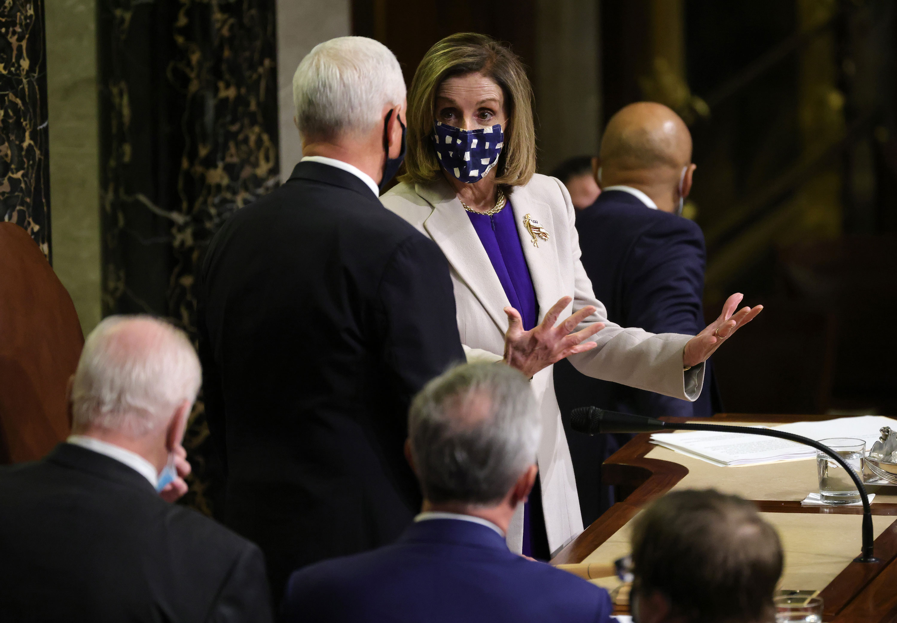 Speaker of the House Nancy Pelosi talks with Vice President Mike Pence after the conclusion of the count of electoral votes in the House Chamber on January 7.