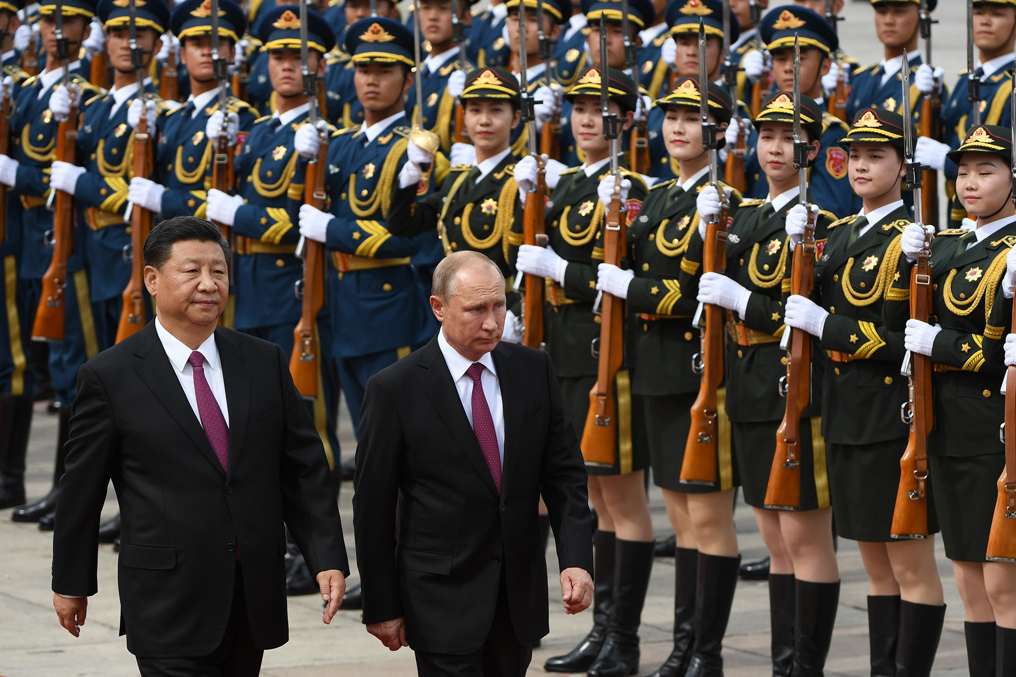 Russian President Vladimir Putin reviews a military honor guard with Chinese leader Xi Jinping during a welcoming ceremony outside the Great Hall of the People in Beijing on June 8, 2018. 