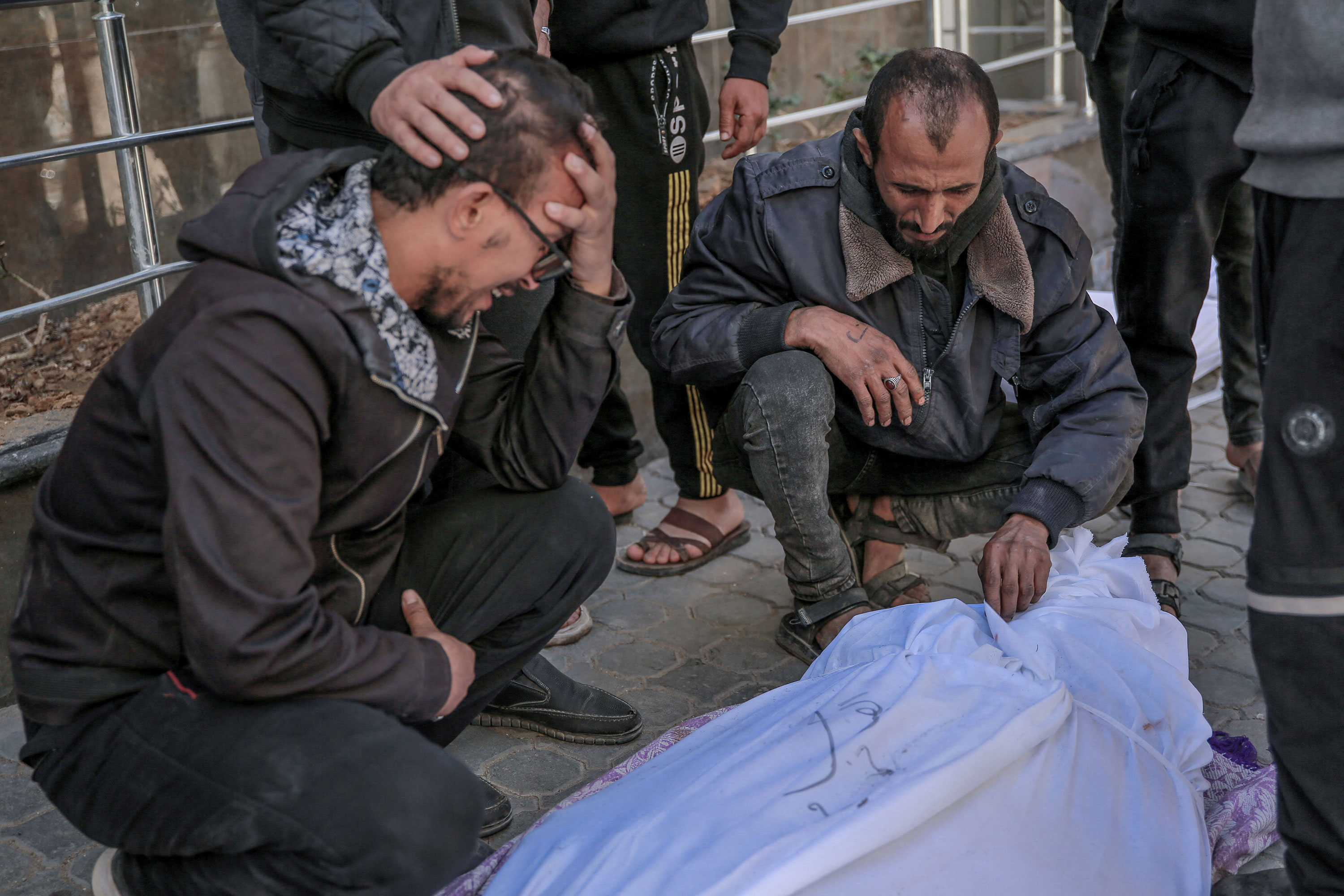 People at Al-Shifa Hospital in Gaza City mourn over the body of a Palestinian killed amid Israeli gunfire and panic at an aid distribution point on February 29. 