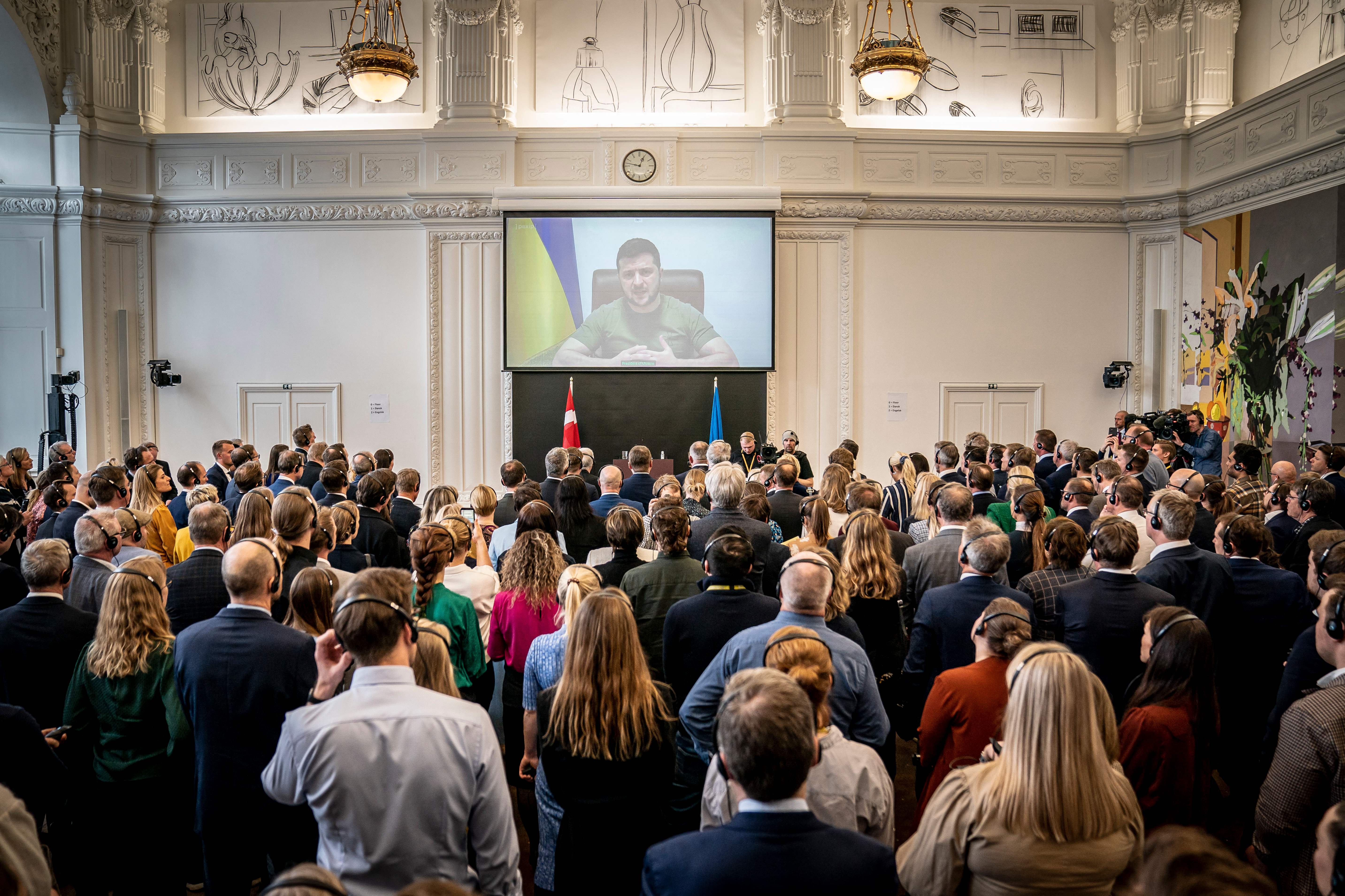 Ukrainian President Volodymyr Zelensky is seen on a screen as he speaks in a video broadcast to members of the Danish Parliament at Christiansborg Castle in Copenhagen on March 29.
