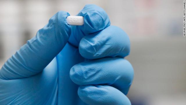 A pharmacy worker holds a hydroxychloroquine pill at a pharmacy in Provo, Utah, on May 20, 2020.