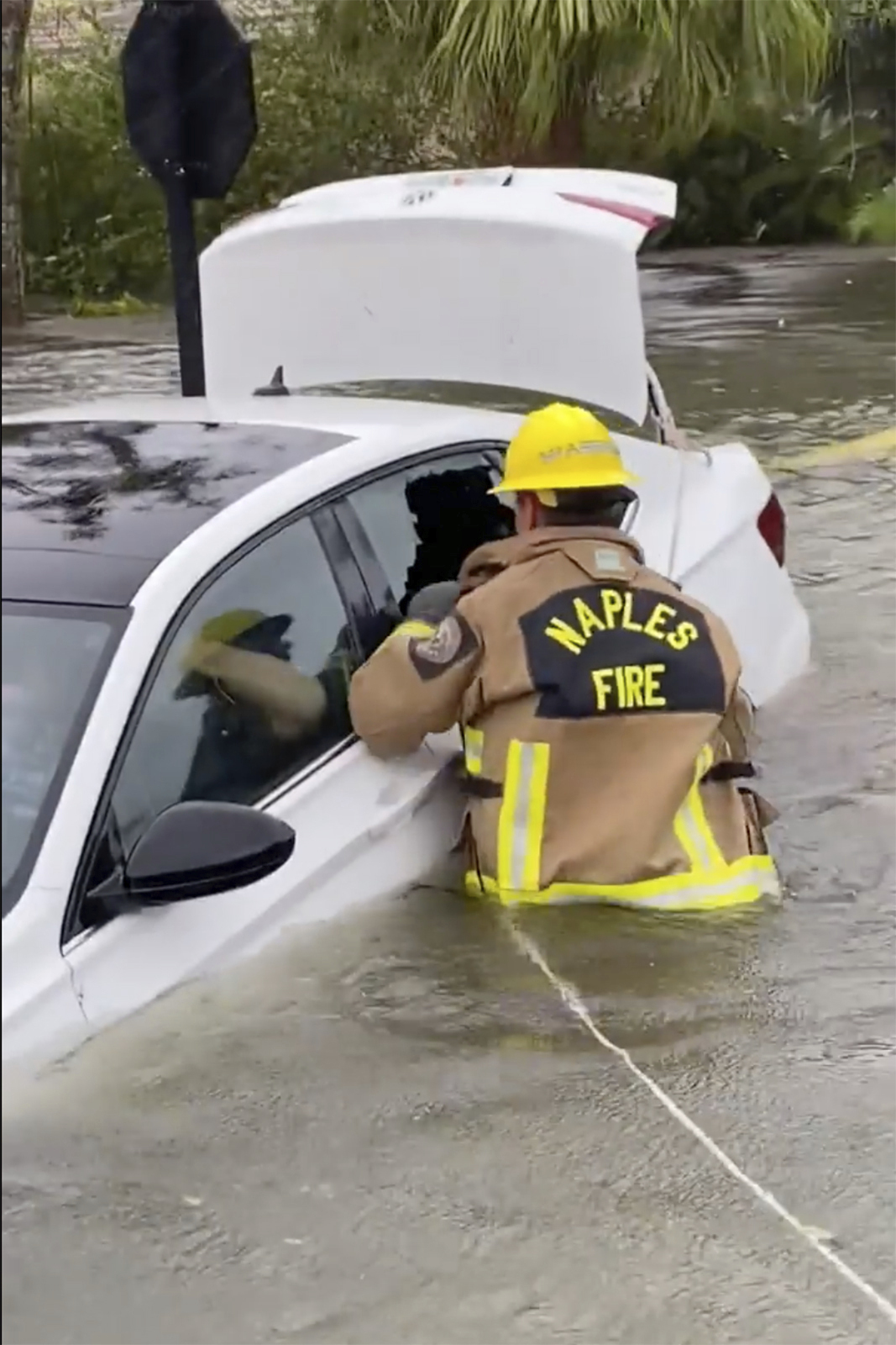 Naples Fire-Rescue Department crews help rescue a stranded motorist in Naples, Florida, on Thursday.