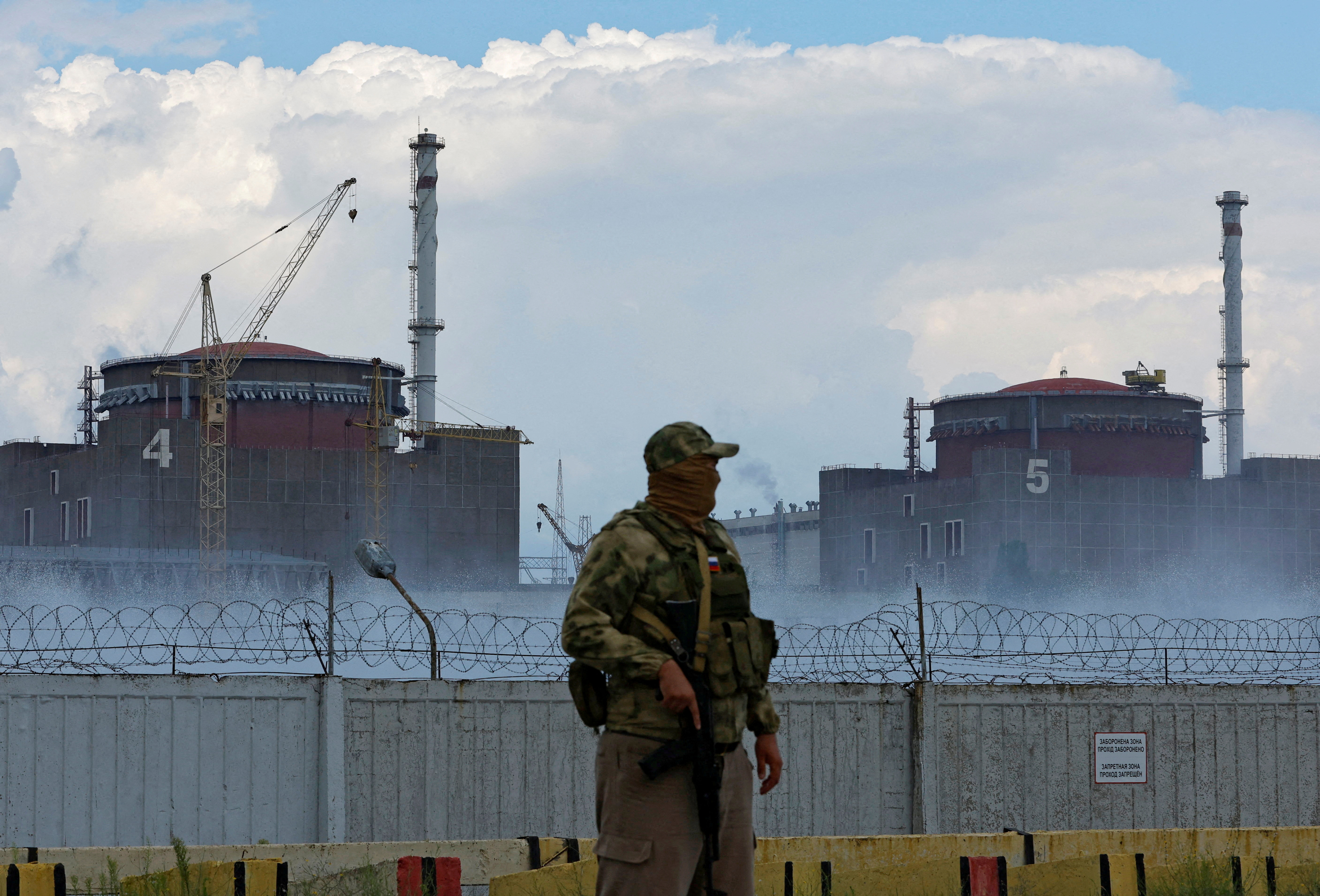 A serviceman with a Russian flag on his uniform stands guard near the Zaporizhzhia nuclear power plant on August 4.